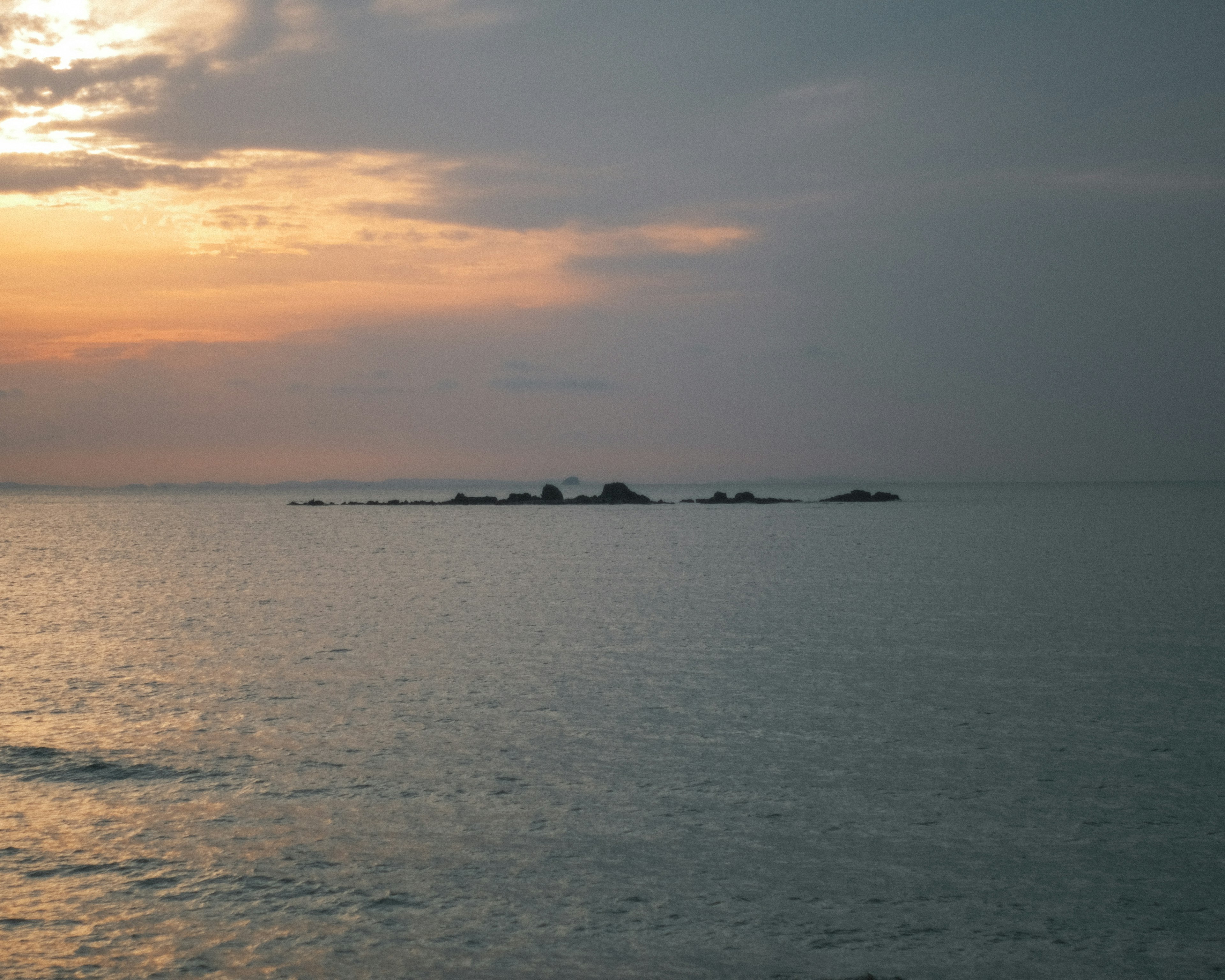 Pemandangan laut yang tenang dengan matahari terbenam yang indah