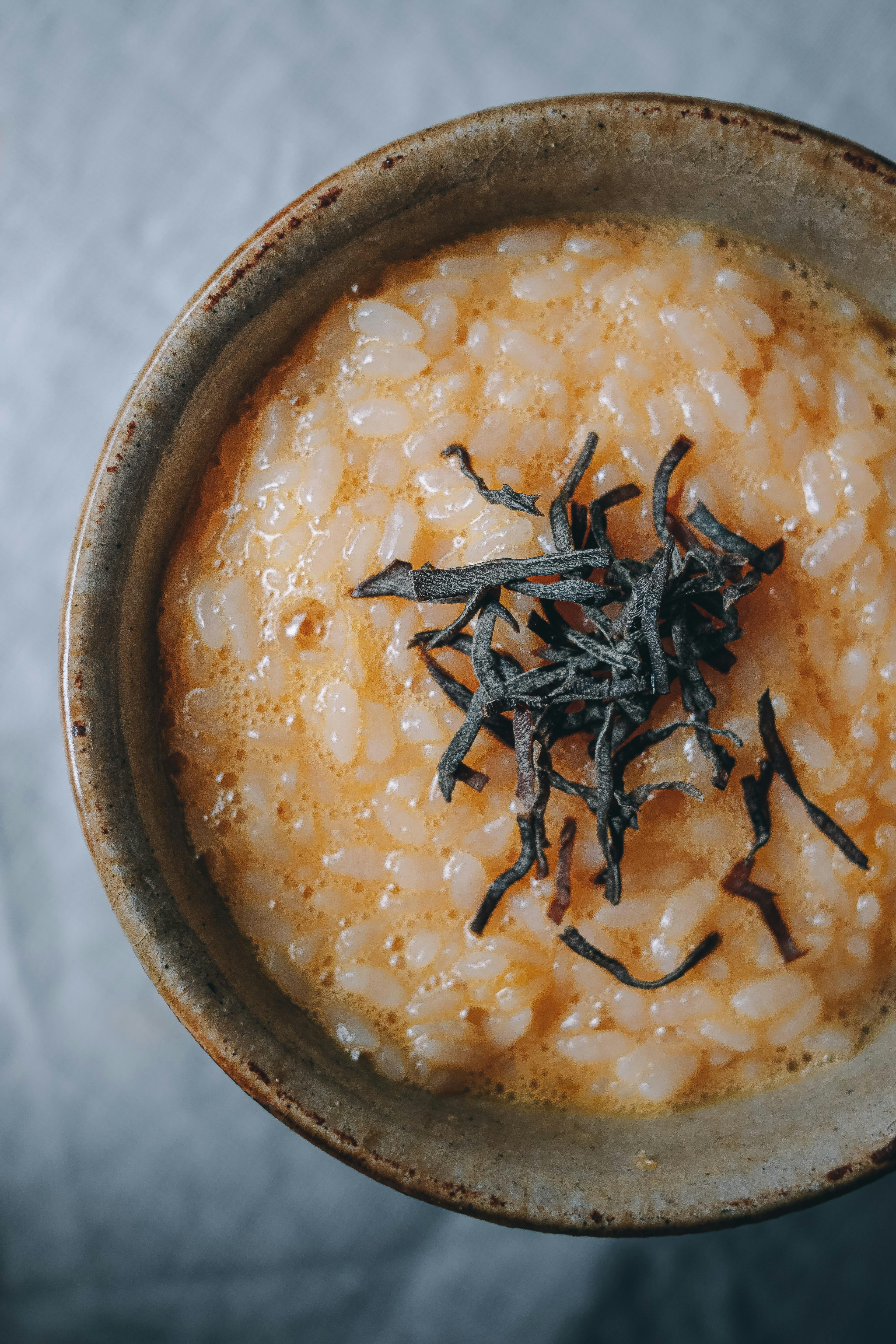 소박한 그릇에 담긴 해조류가 얹힌 크리미한 쌀 요리