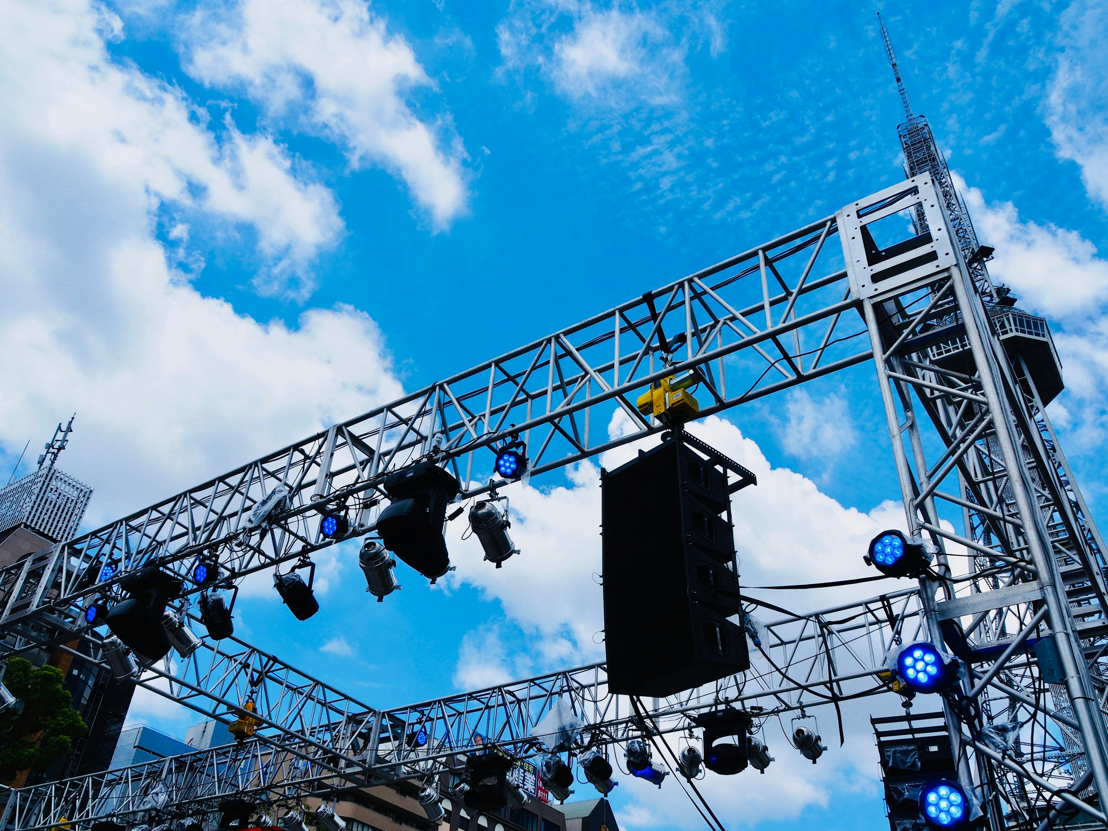 Iluminación de escenario y altavoces para un evento musical bajo un cielo azul