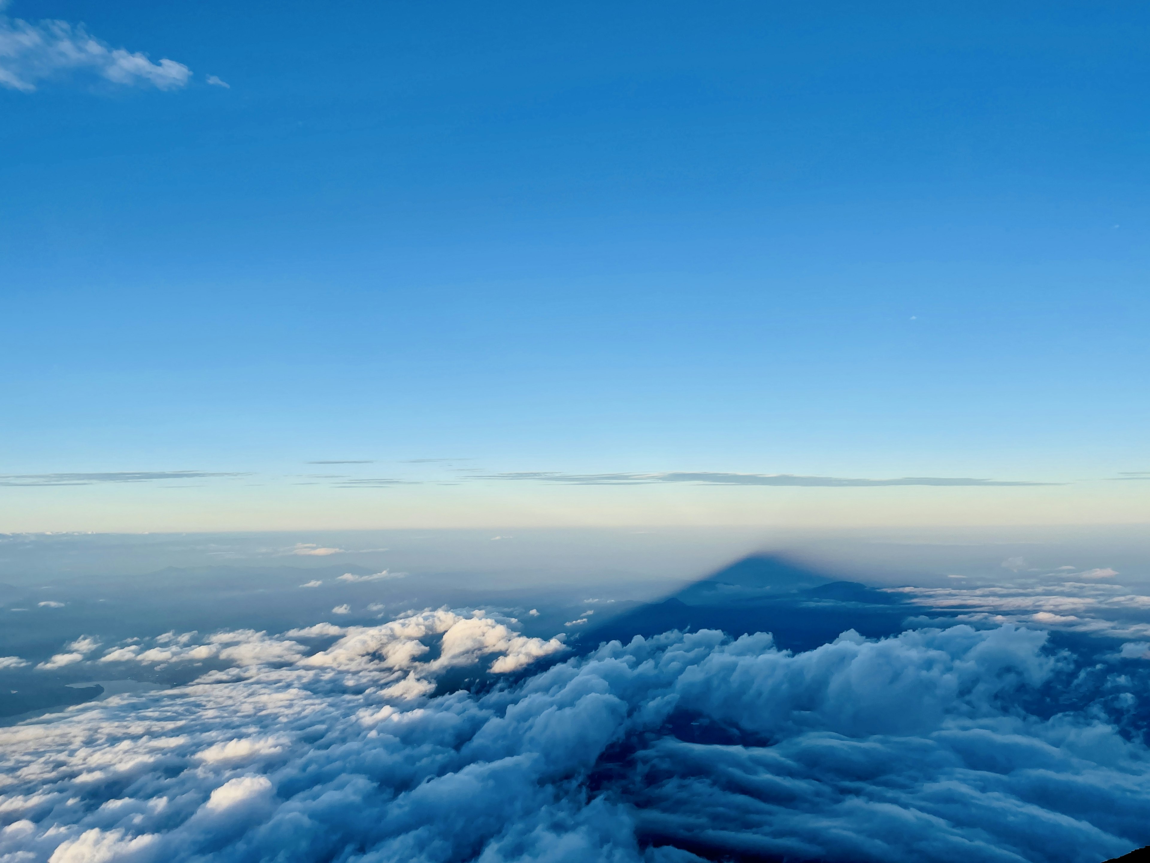 Schatten eines Berges über den Wolken mit klarem blauen Himmel