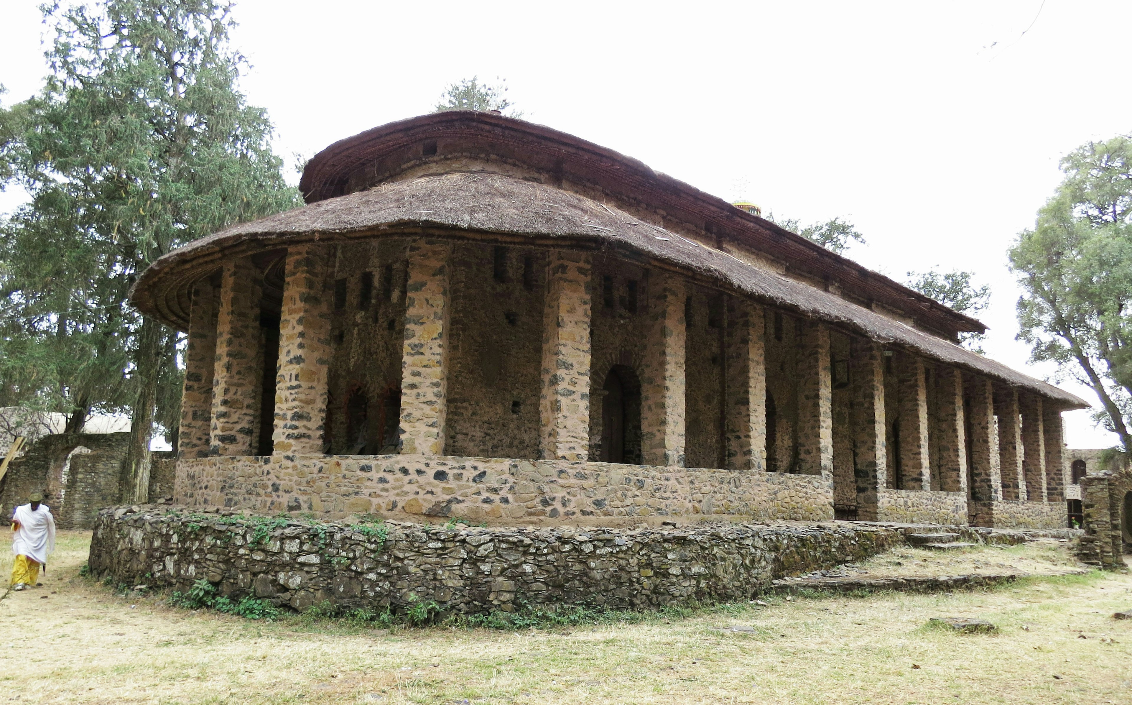 古代の石造りの建物、柱と茅葺き屋根が特徴