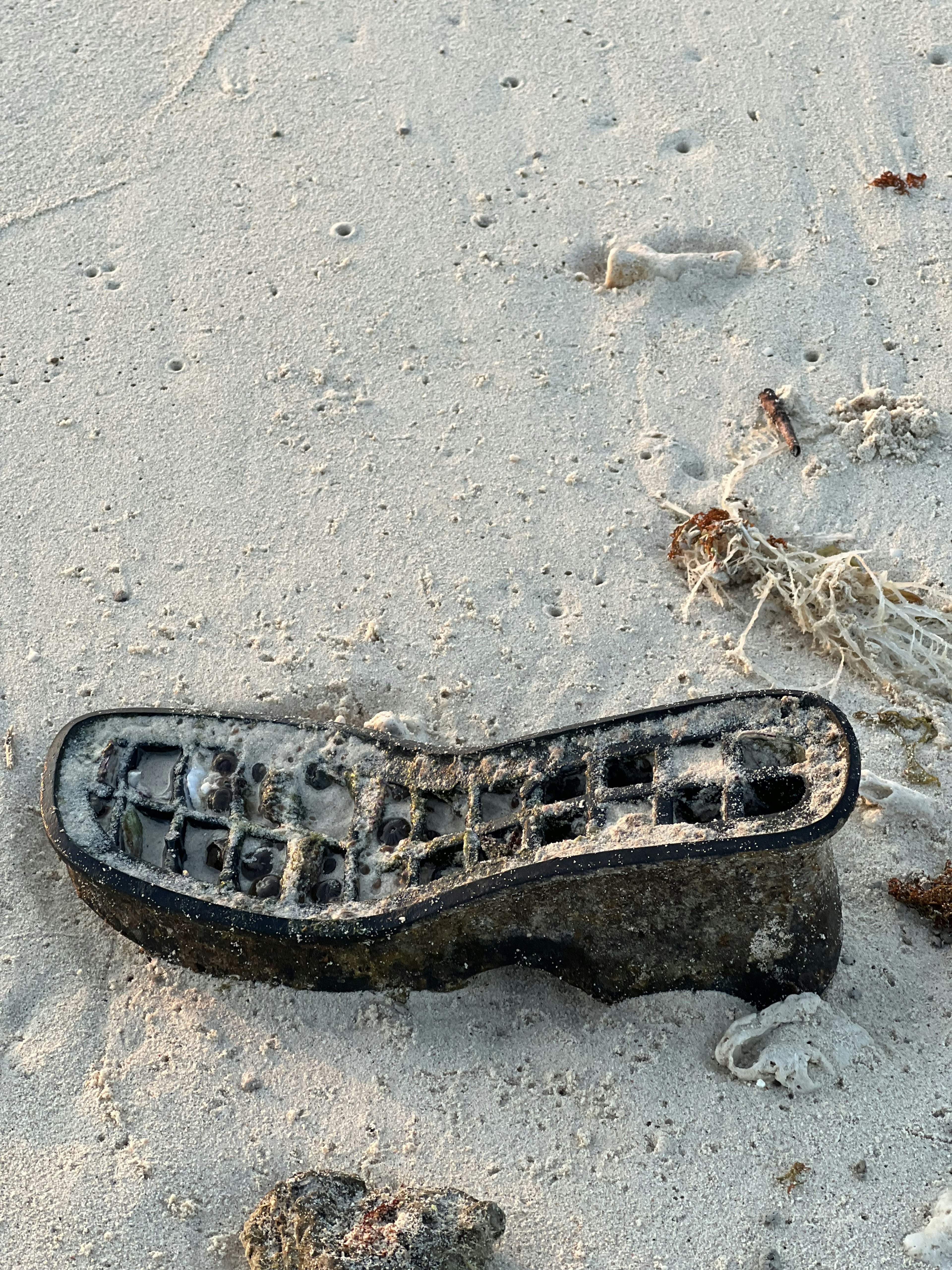 Sepatu tua tergeletak di pantai