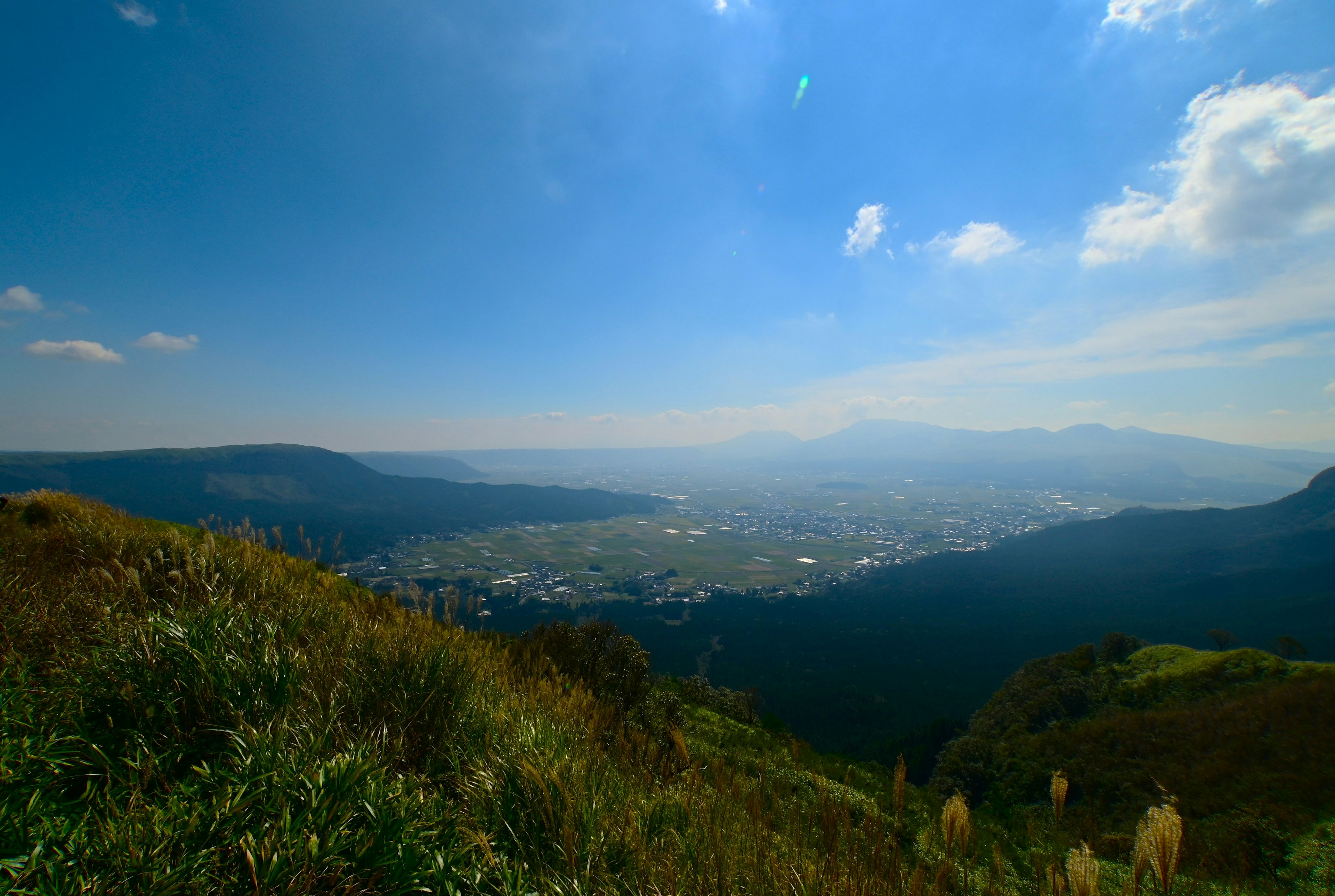 青空と雲の下に広がる山と谷の景色