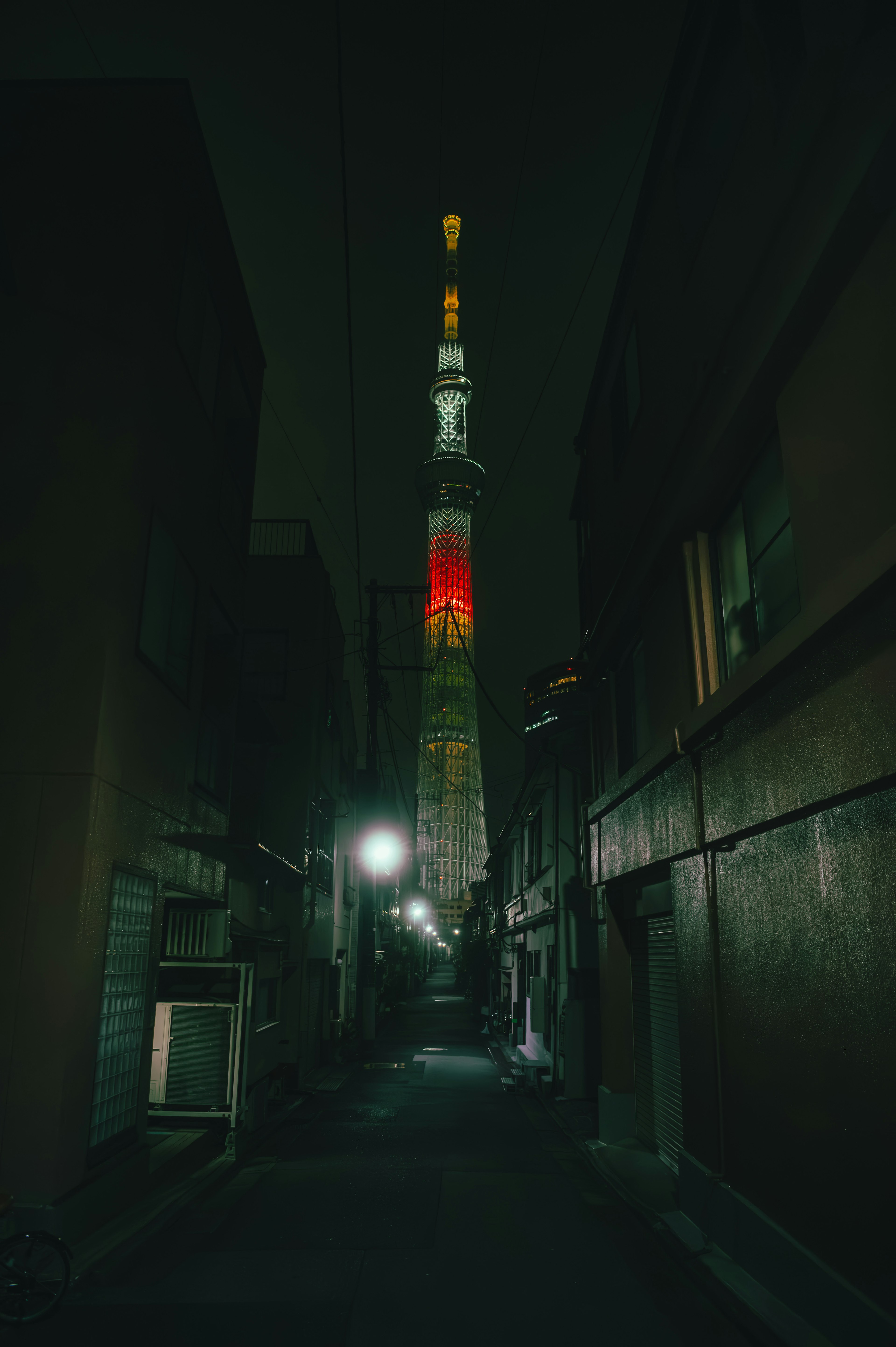 夜の東京スカイツリーが狭い路地から見える