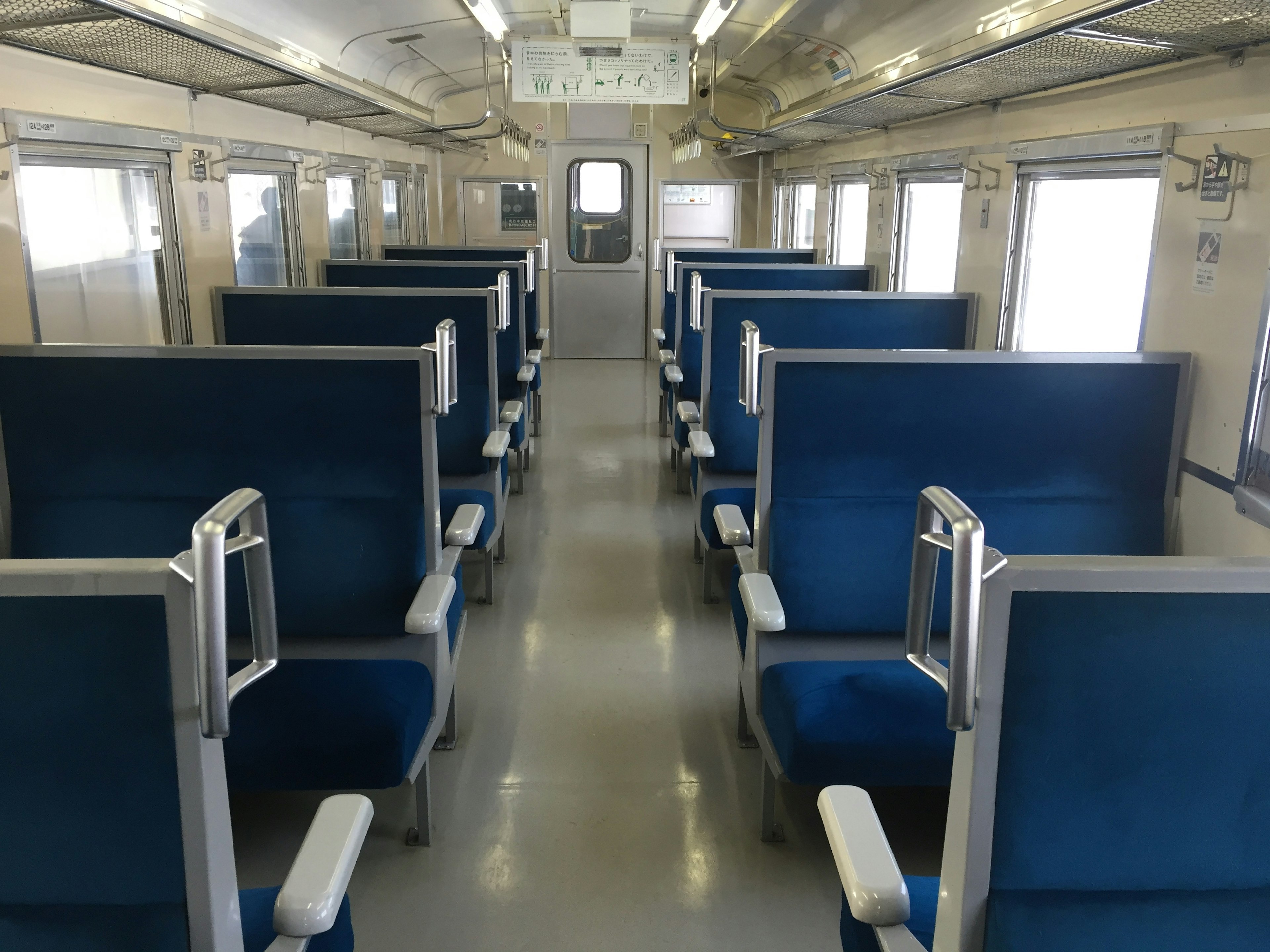 Interior view of a train carriage with blue seats