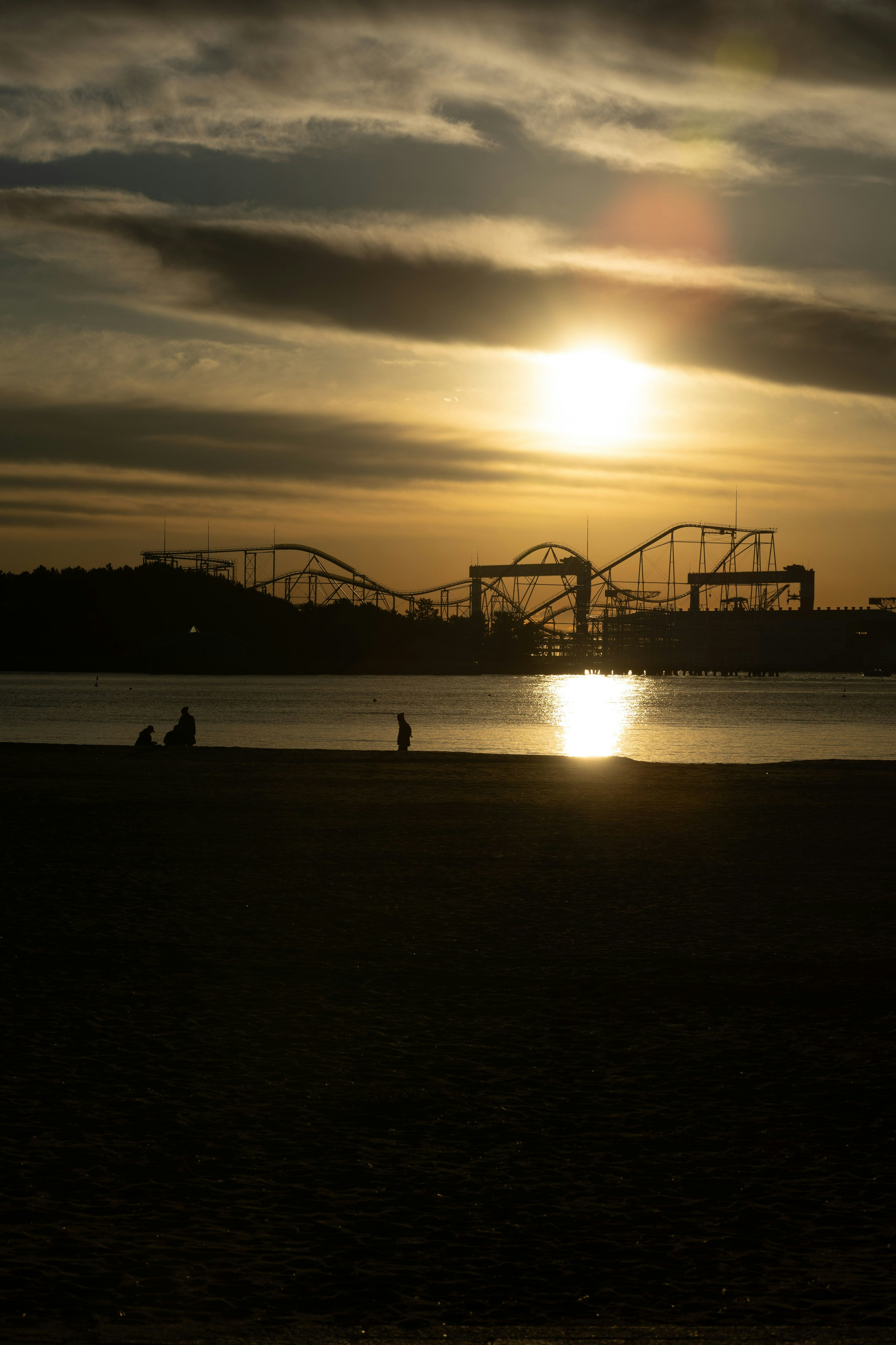 Silhouette d'un parc d'attractions au coucher de soleil sur la plage