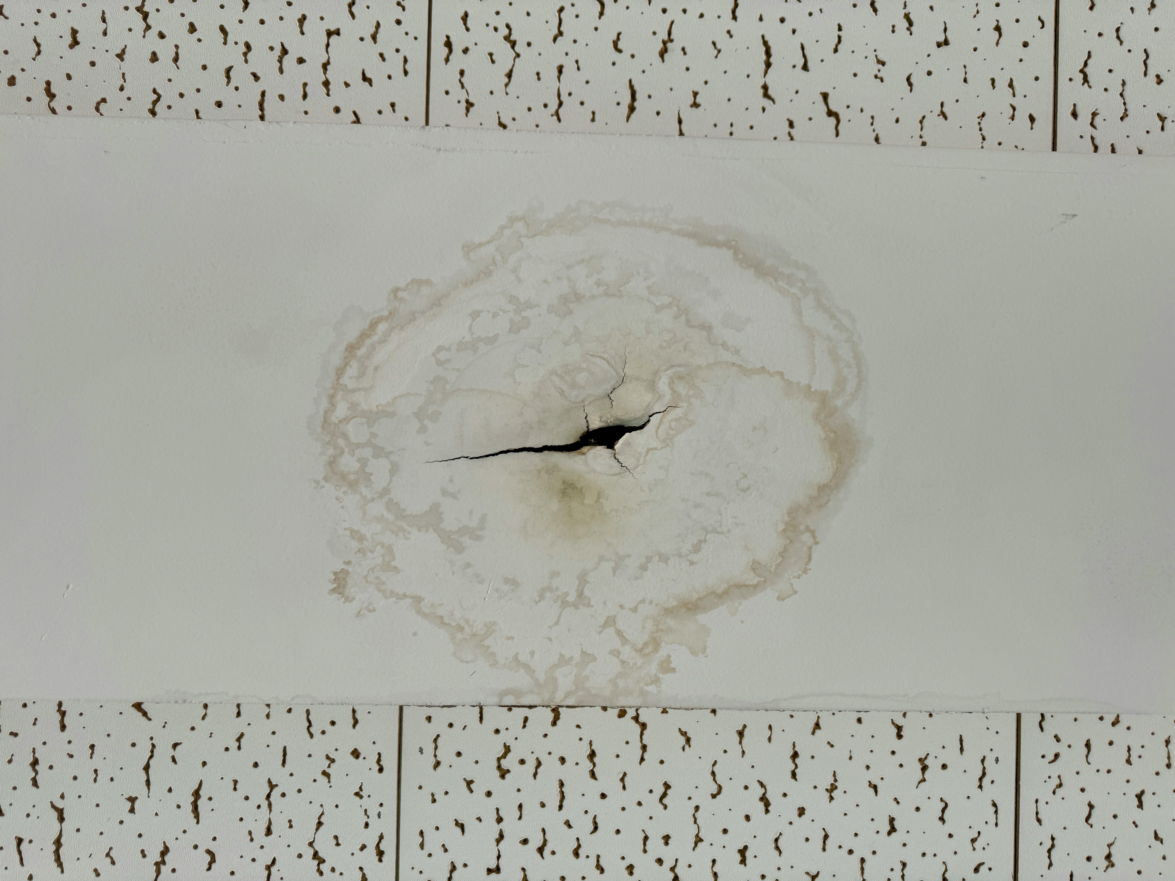 Ceiling damage shows a central black crack surrounded by burnt marks