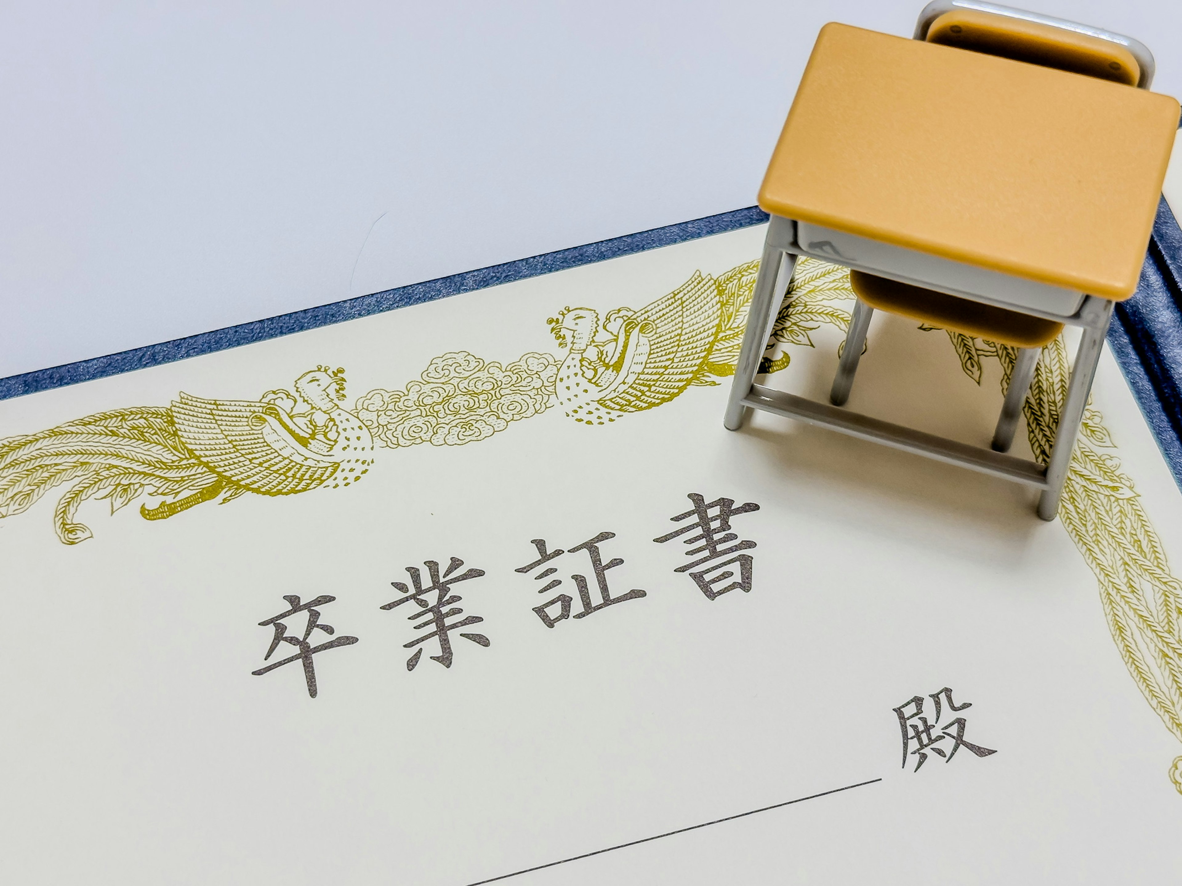 Image d'un certificat de graduation avec du texte japonais et un bureau miniature