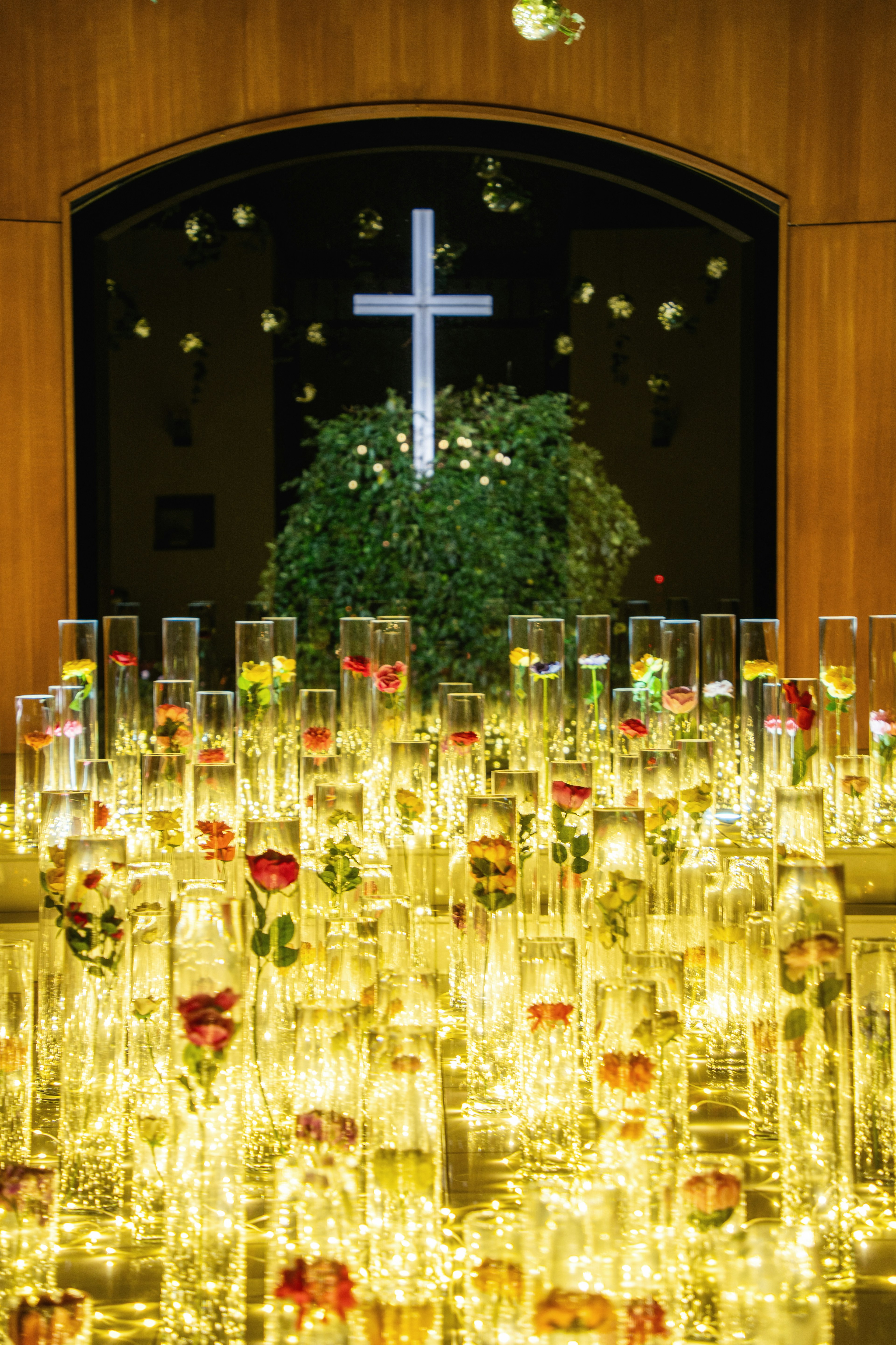 Un espace lumineux avec une croix et des arrangements floraux