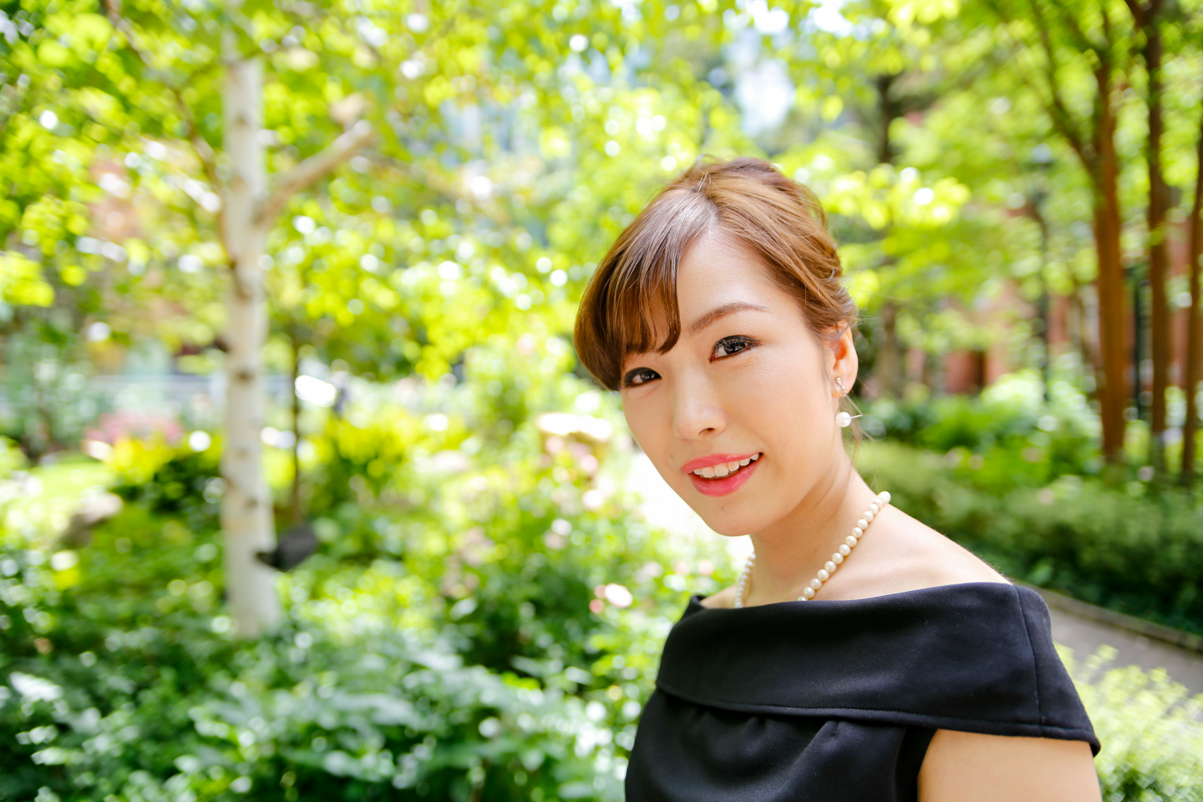 Portrait d'une femme souriante dans un jardin luxuriant