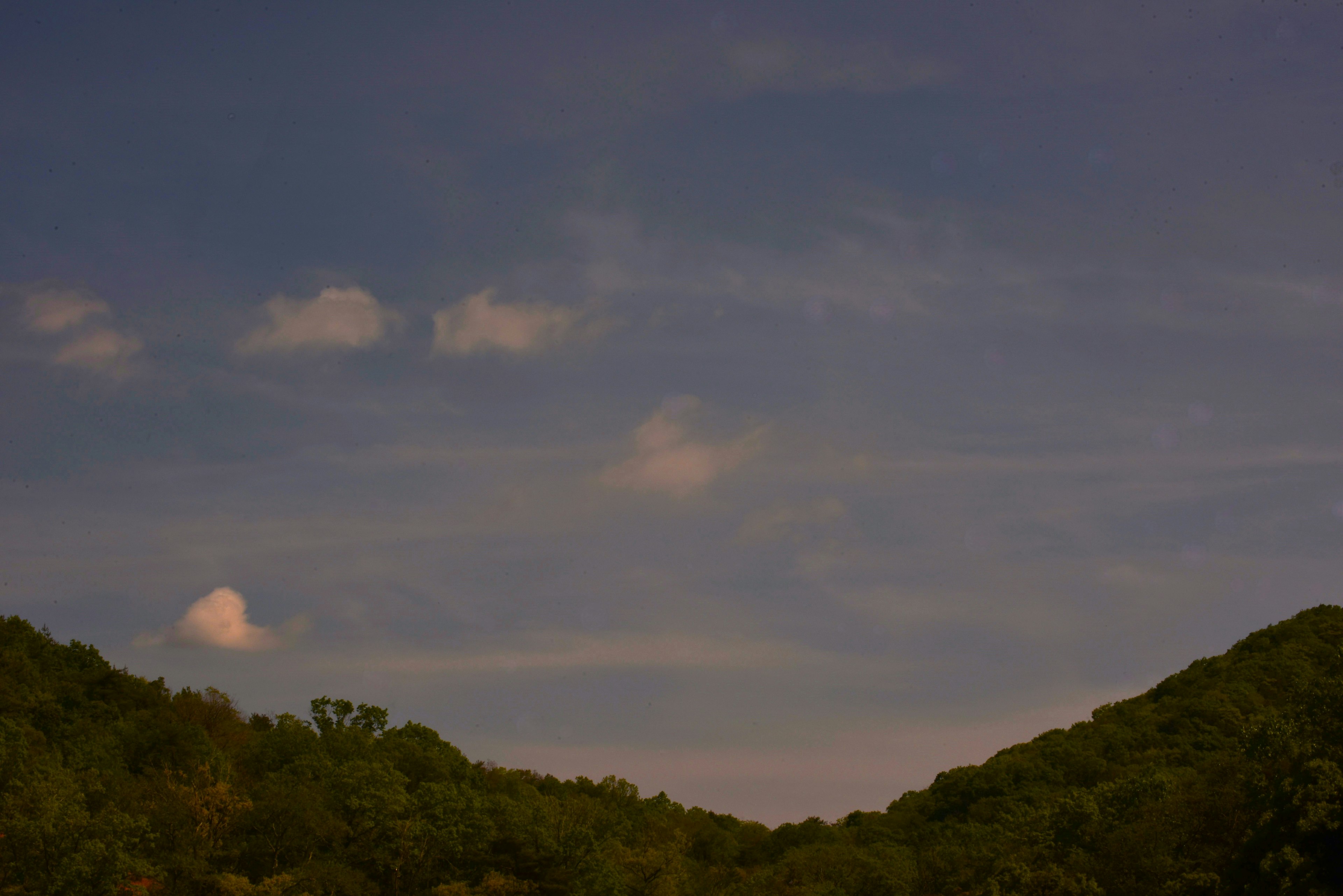 Silhouette von Bergen unter einem blauen Himmel mit verstreuten Wolken