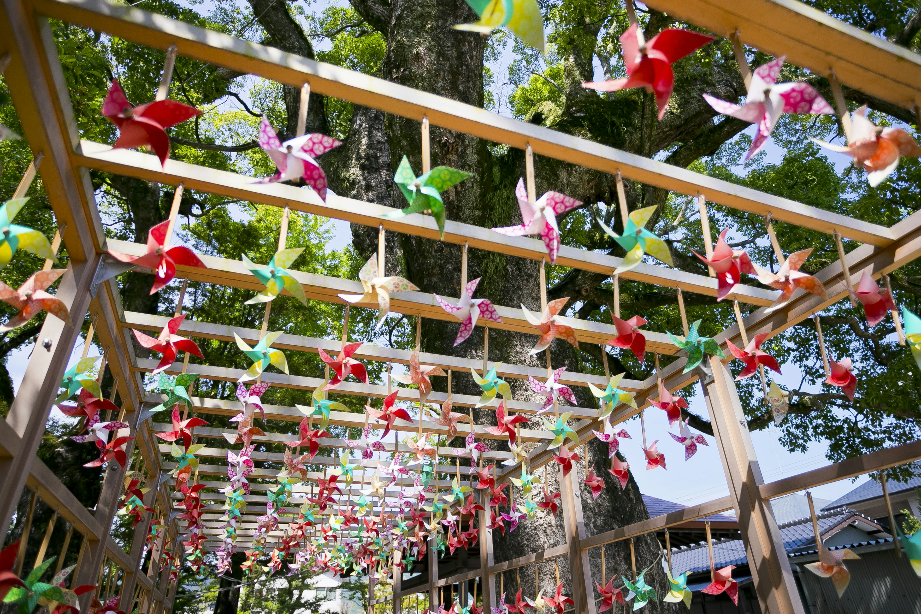 Pájaros de origami coloridos colgando de una estructura de madera