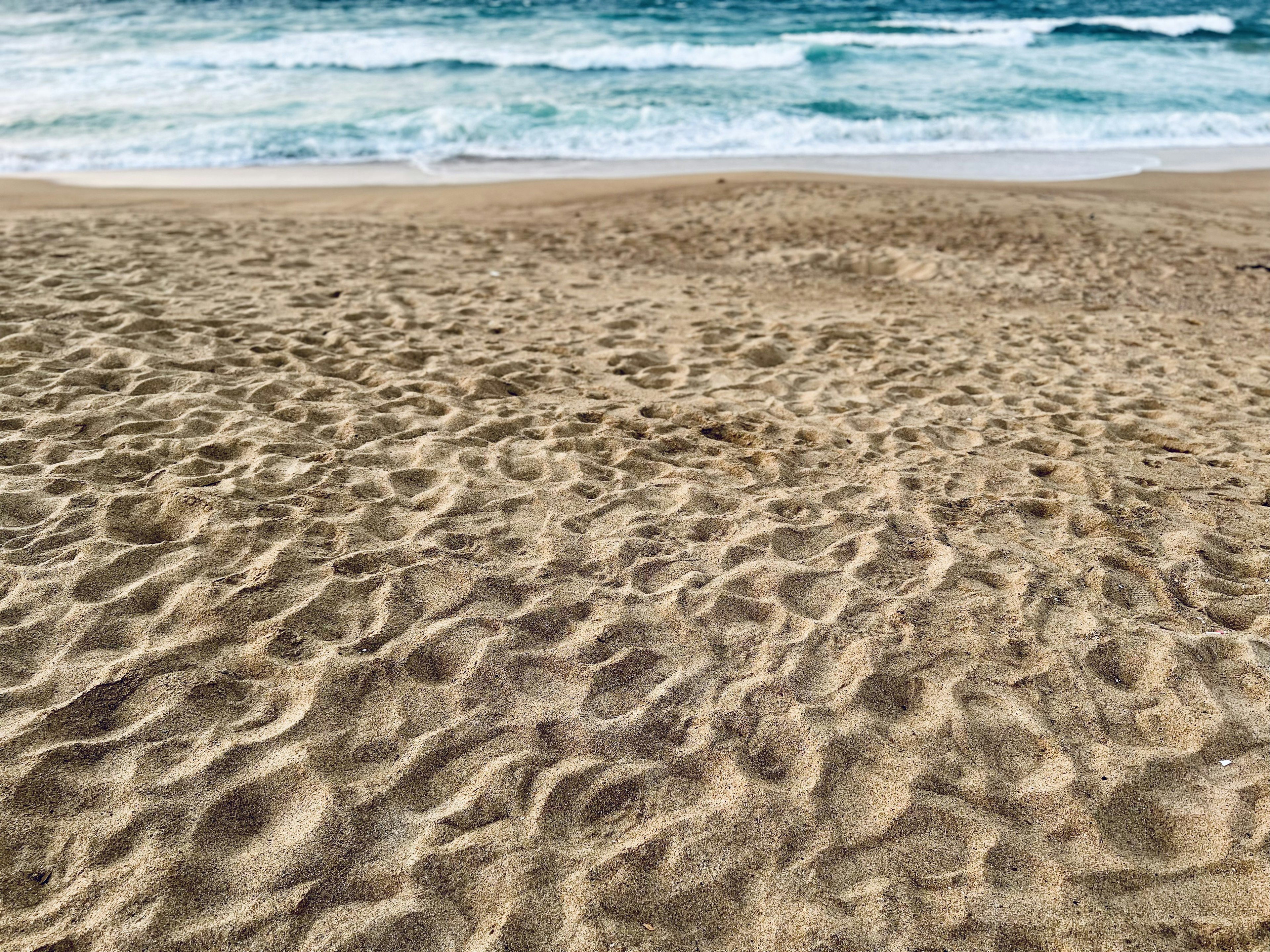 Sandy Strand mit Wellenmustern und Blick auf den Ozean