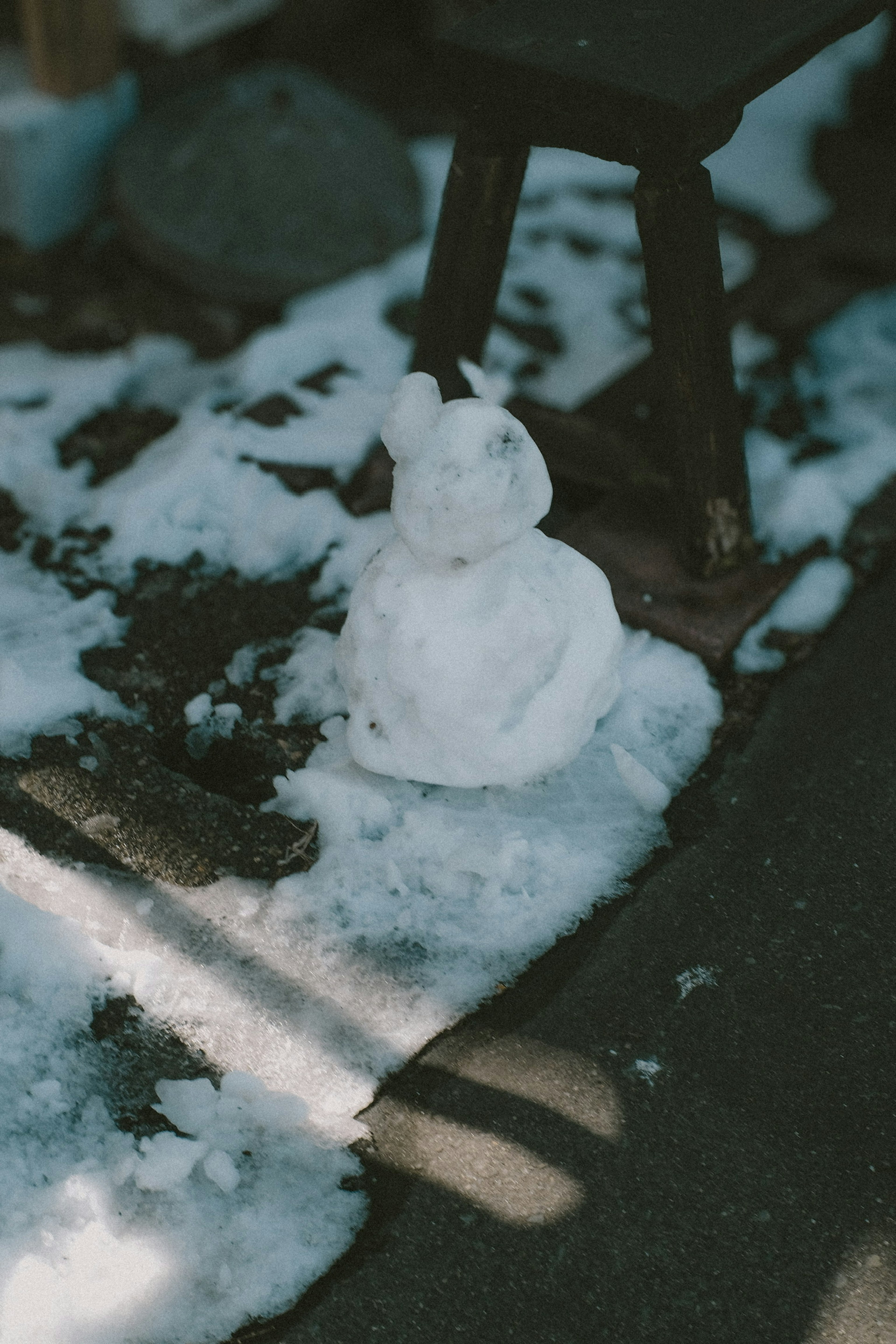 Scultura di coniglio di neve sul terreno con neve circostante