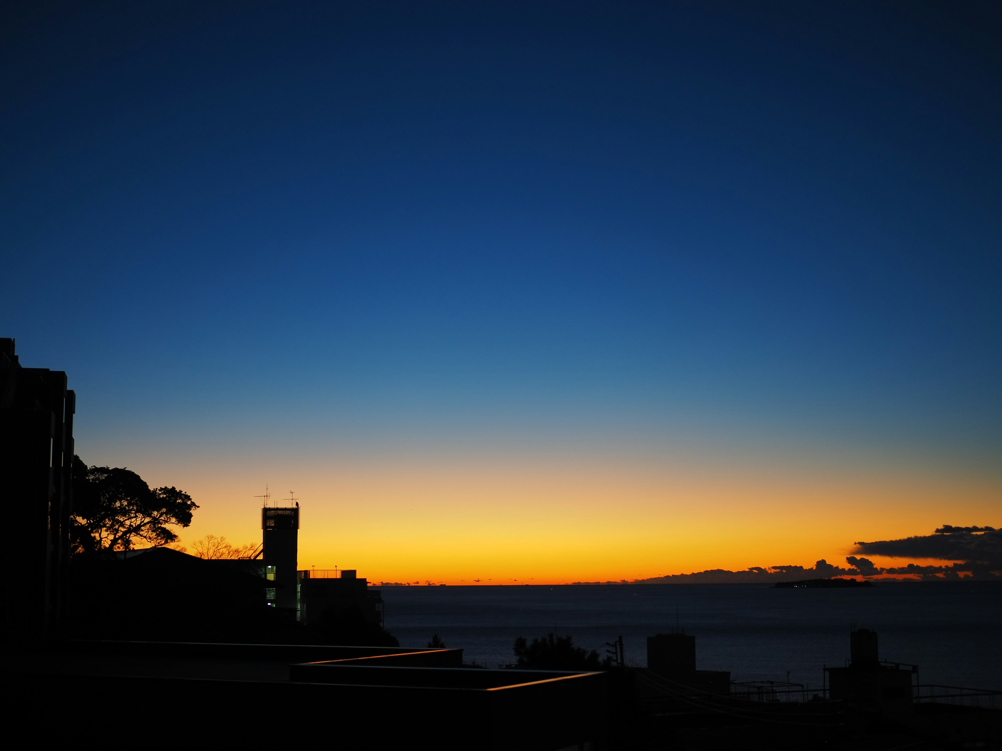 夕焼けの空の美しいグラデーションとシルエットの建物