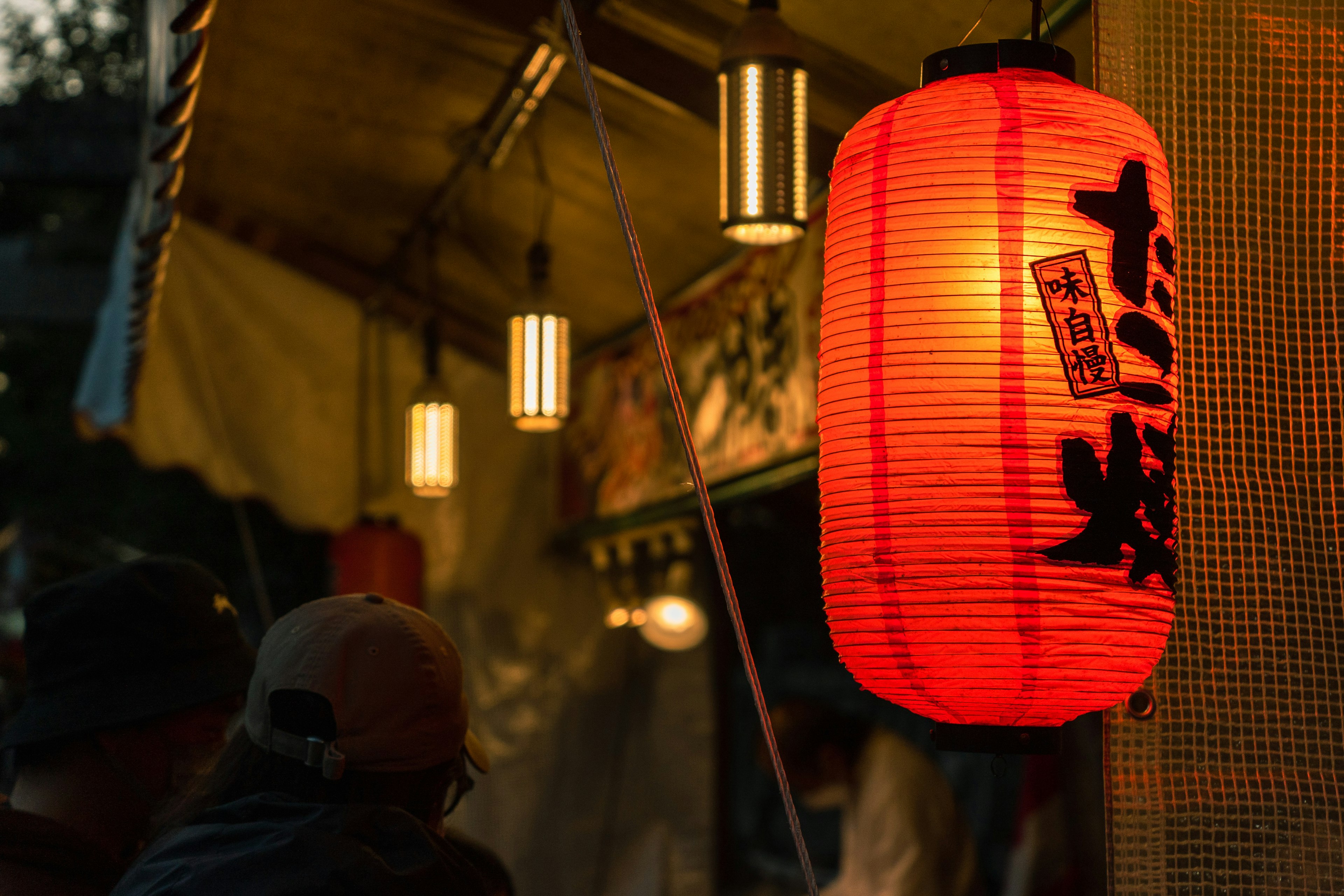 Una vivace lanterna rossa illuminata a un chiosco di cibo di sera