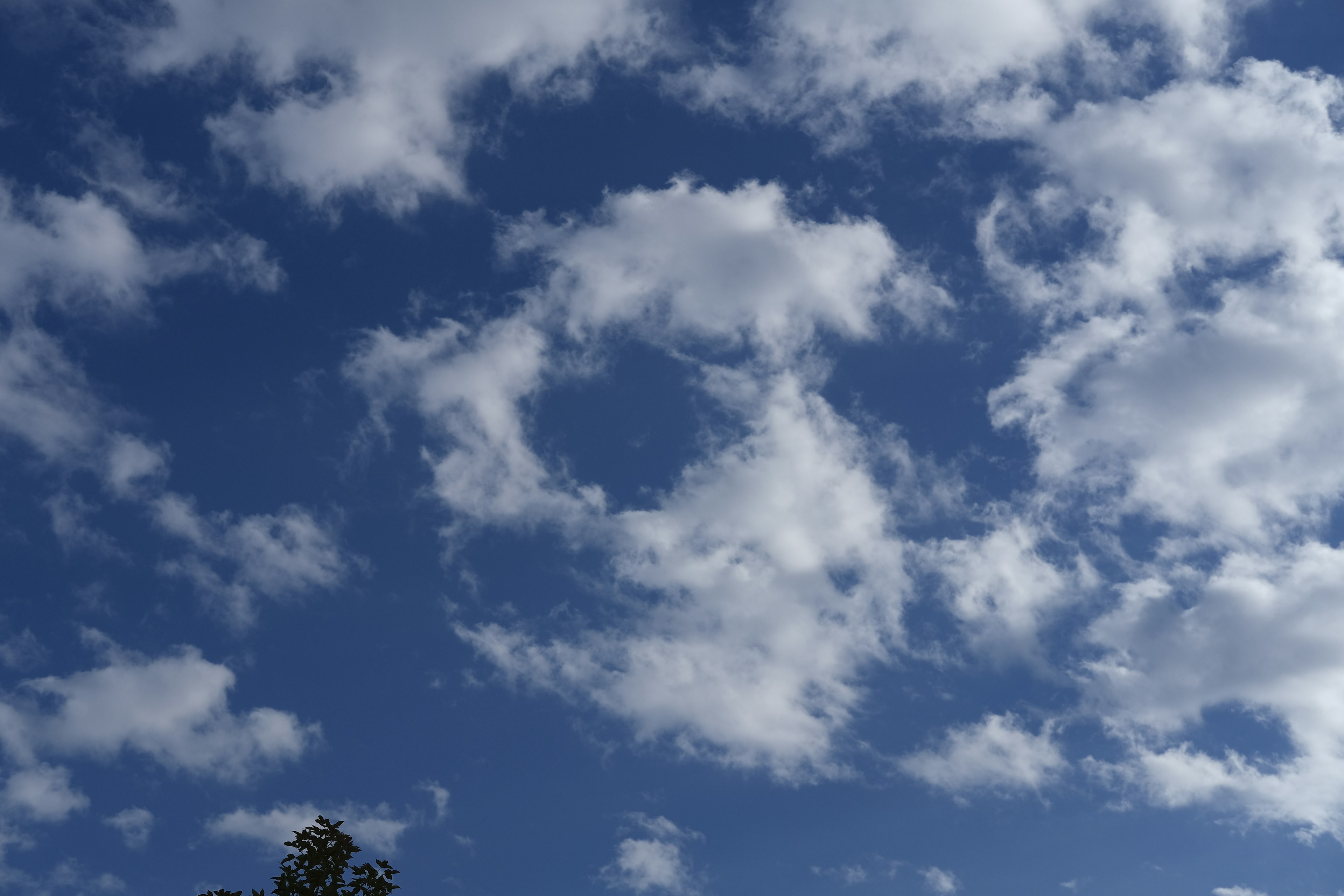 Weiße Wolken in einem blauen Himmel mit einer kreisförmigen Formation