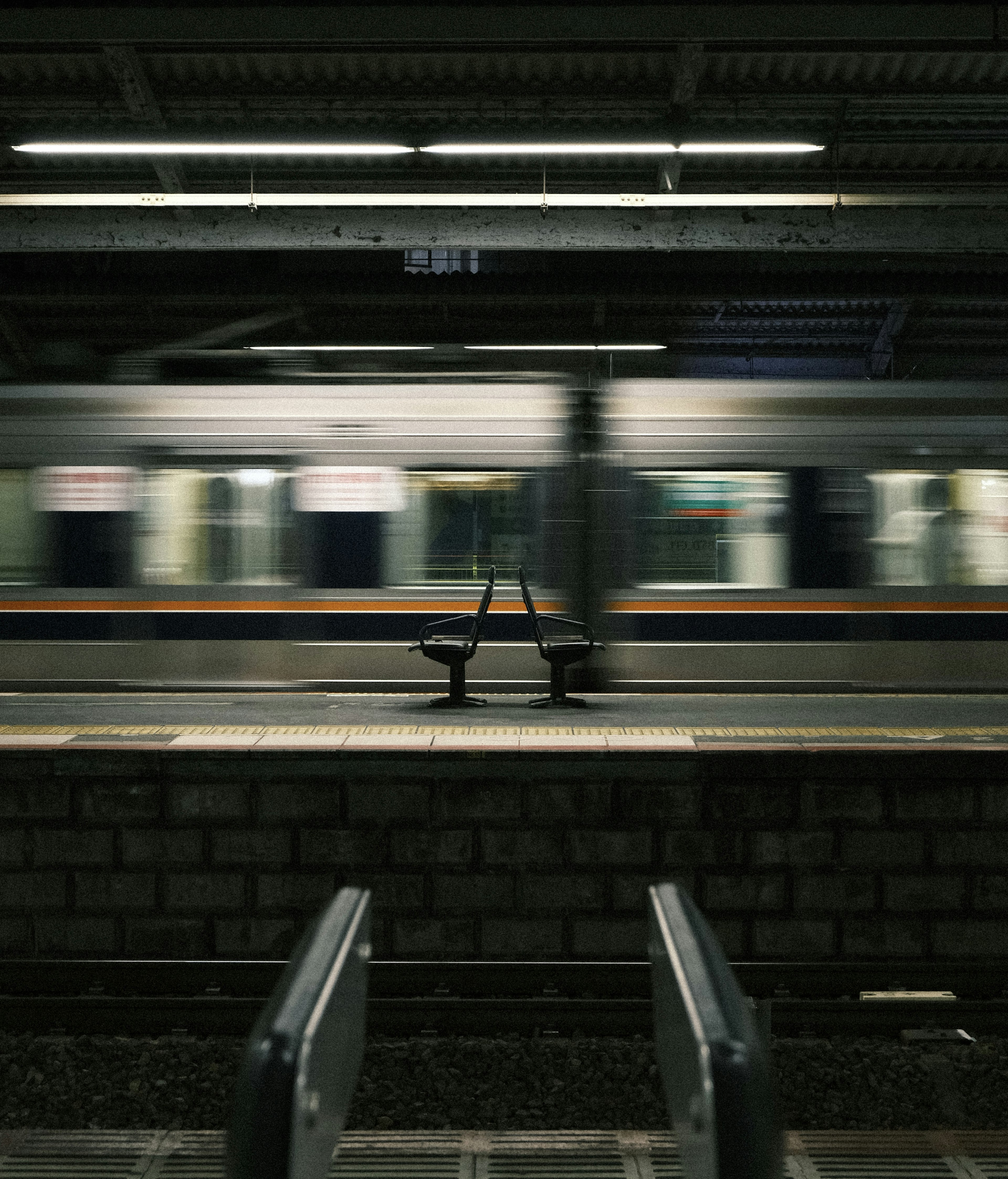 駅のプラットフォームにあるベンチと流れる電車の動き