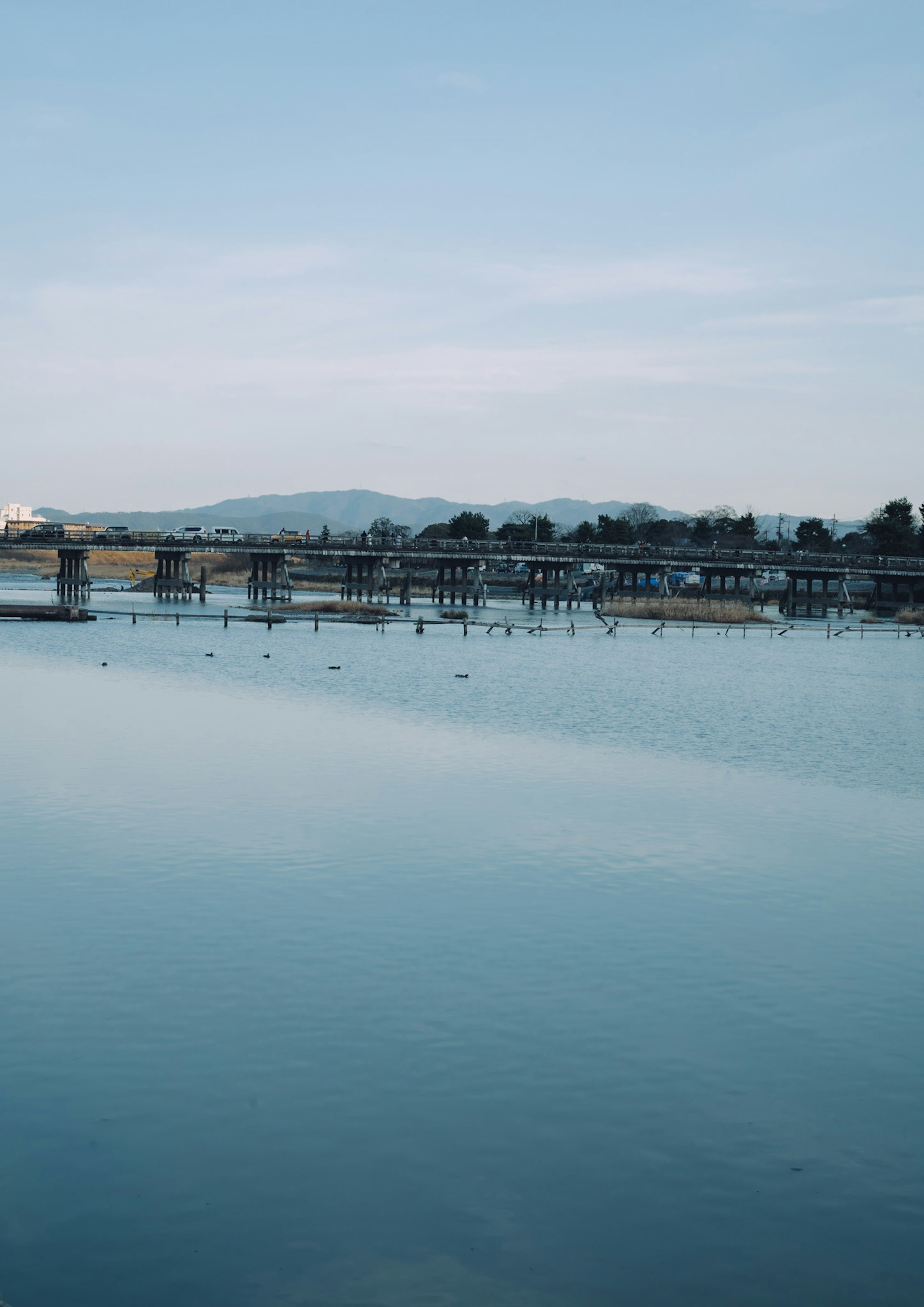 Ruhige Seelandschaft mit reflektierender Brücke und Bergen