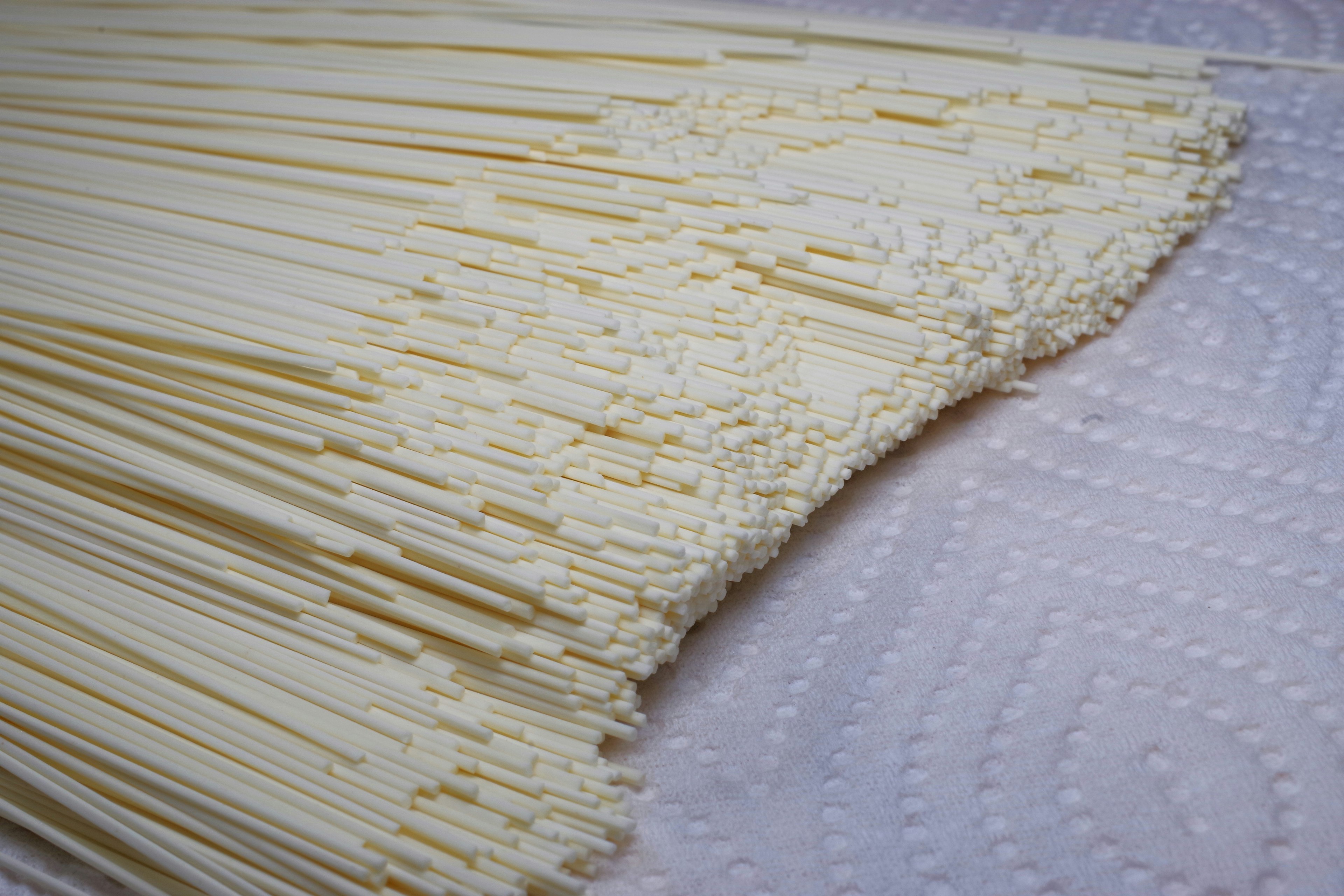 A bundle of long cream-colored noodles arranged neatly