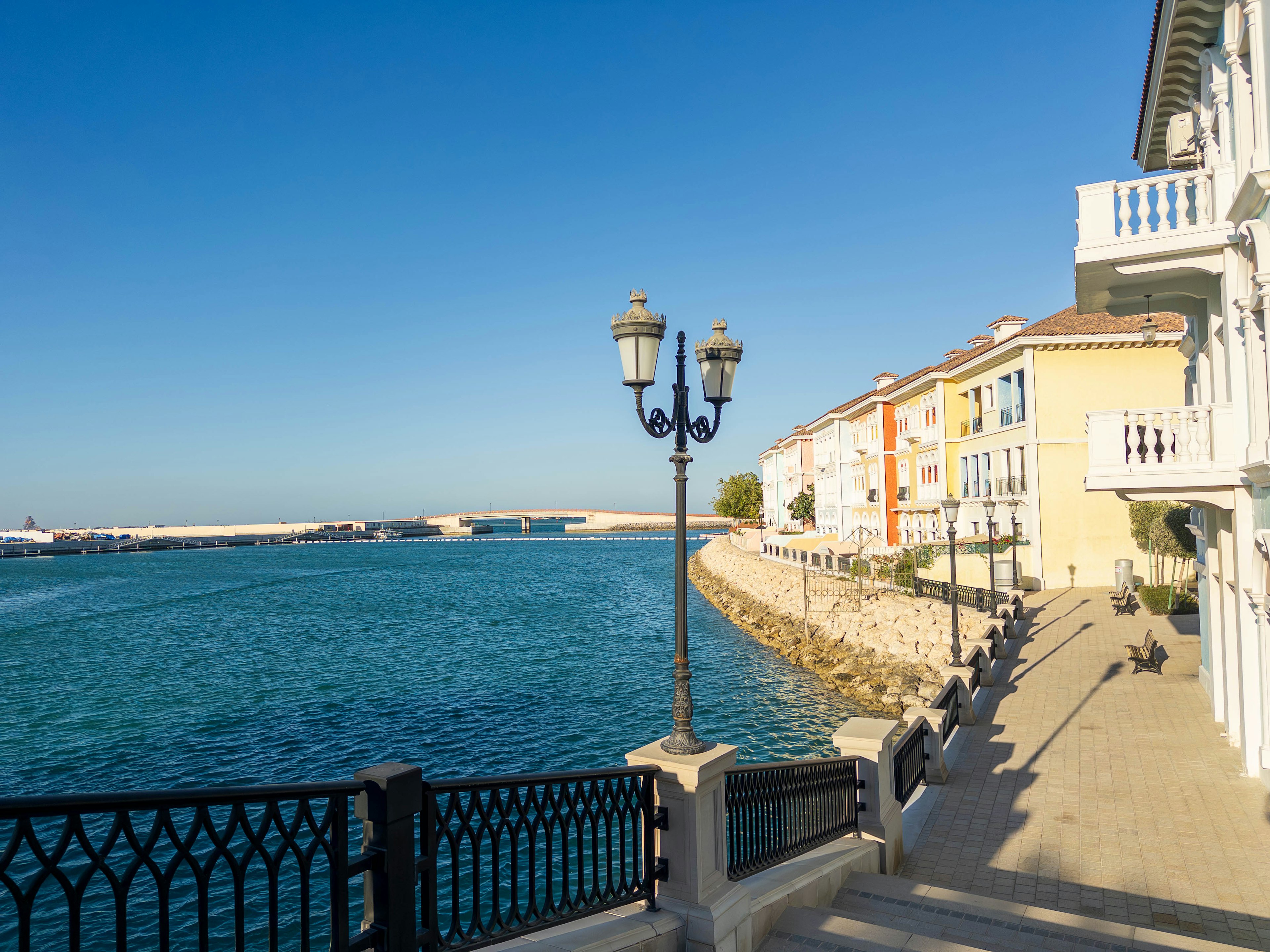 Bellissima passeggiata con edifici colorati lungo l'acqua blu