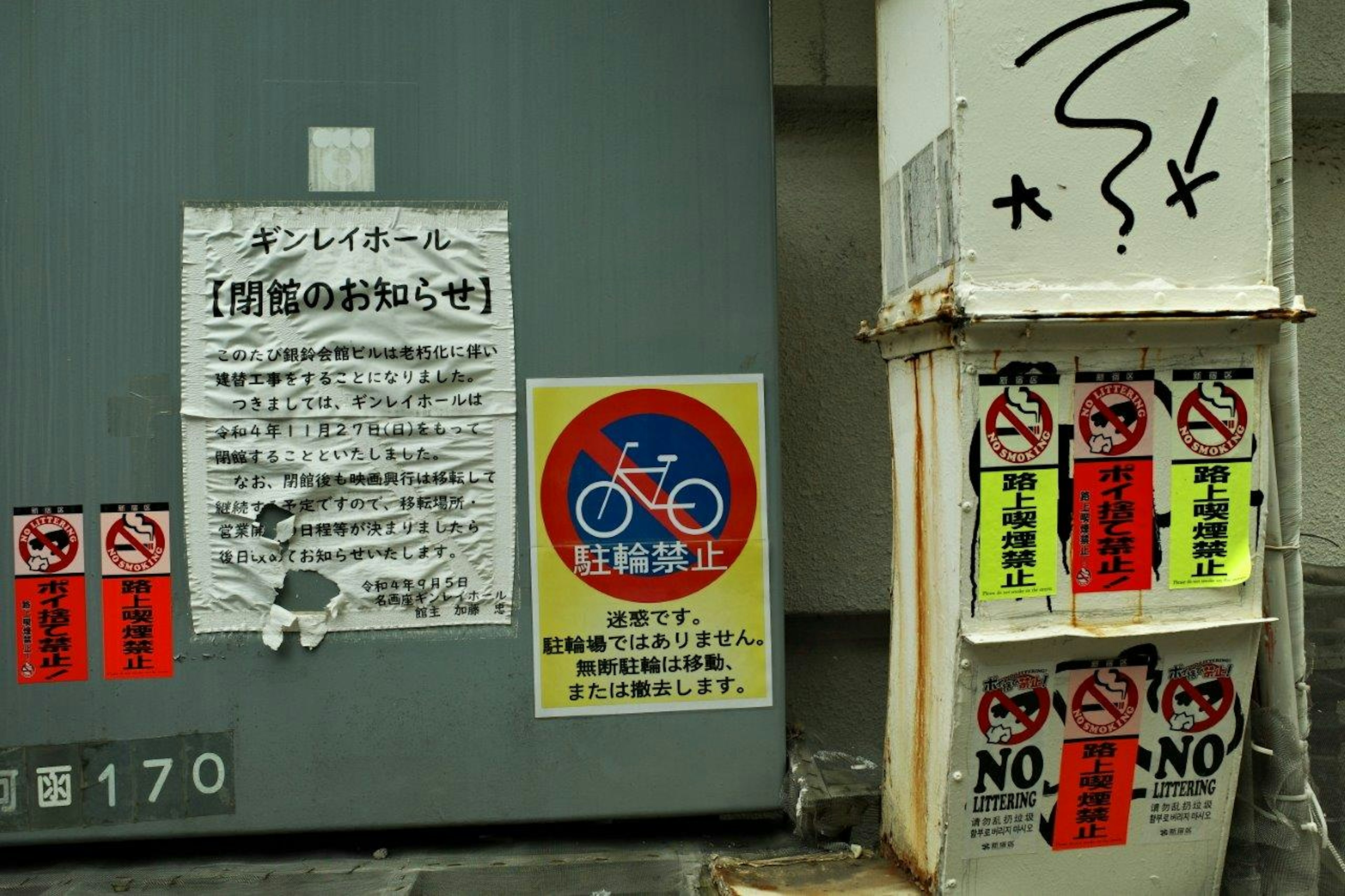 Wall featuring bicycle prohibition sign and various warning notices