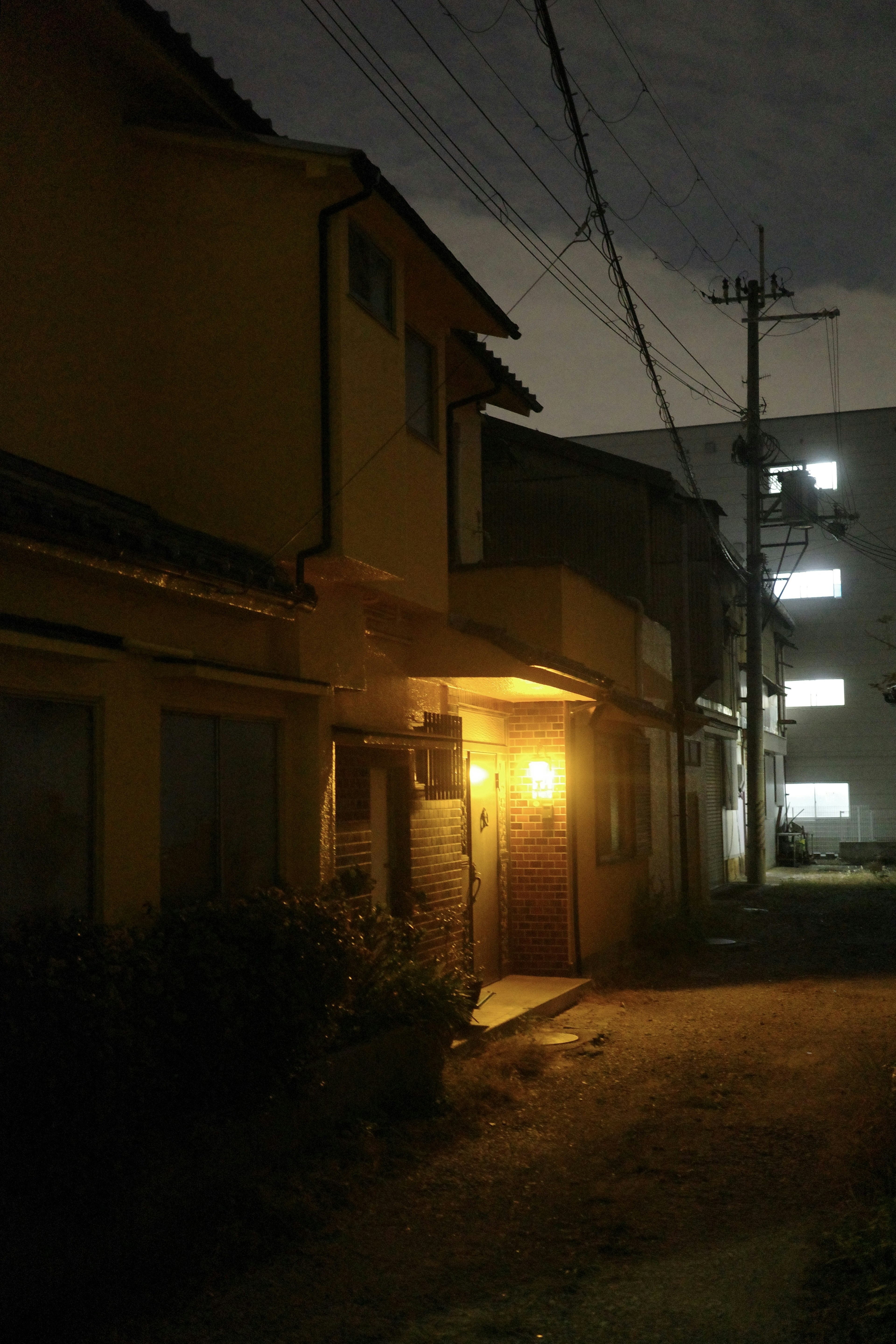 Old house with a warm light on a dim street