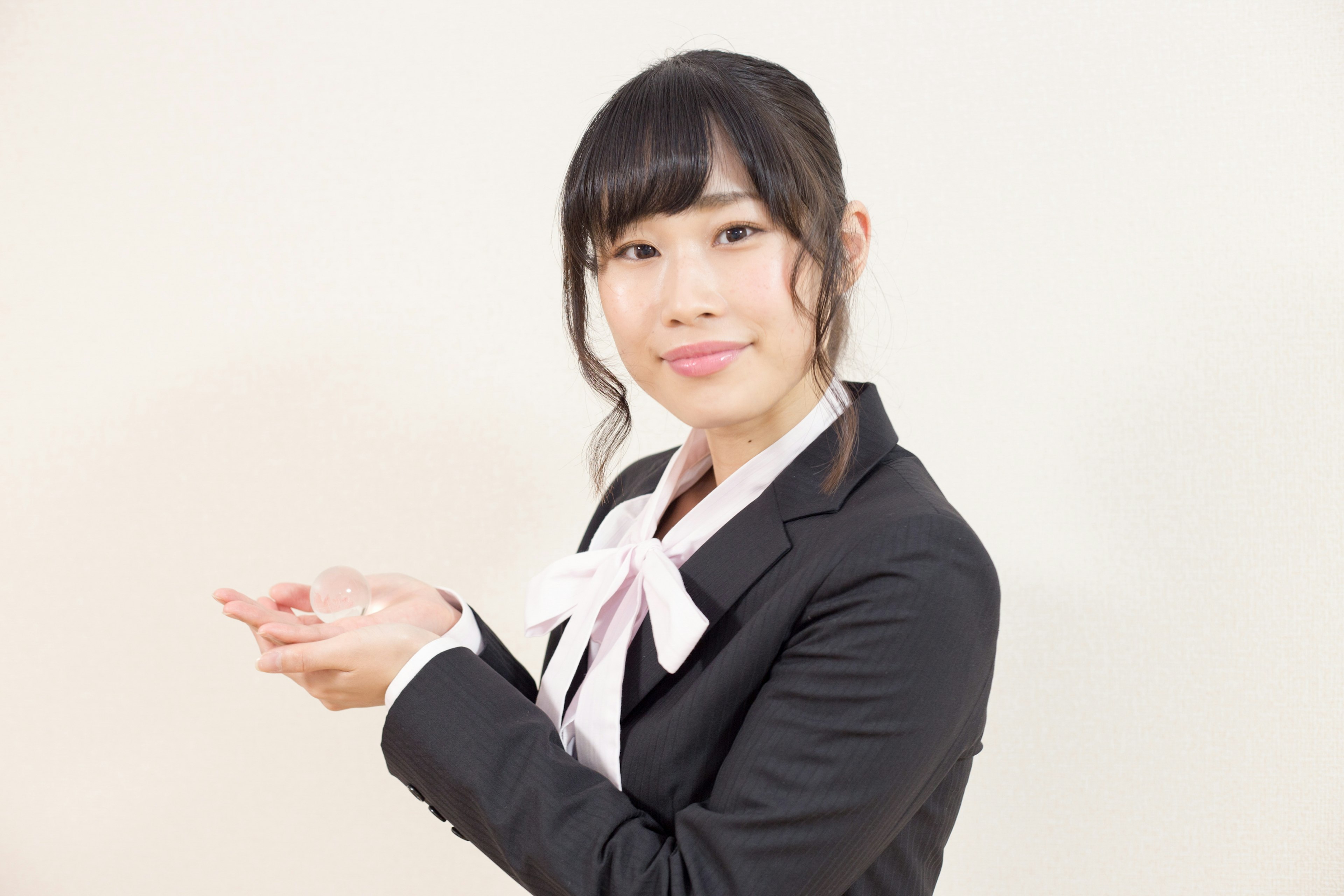 A woman in a business suit extending her hands