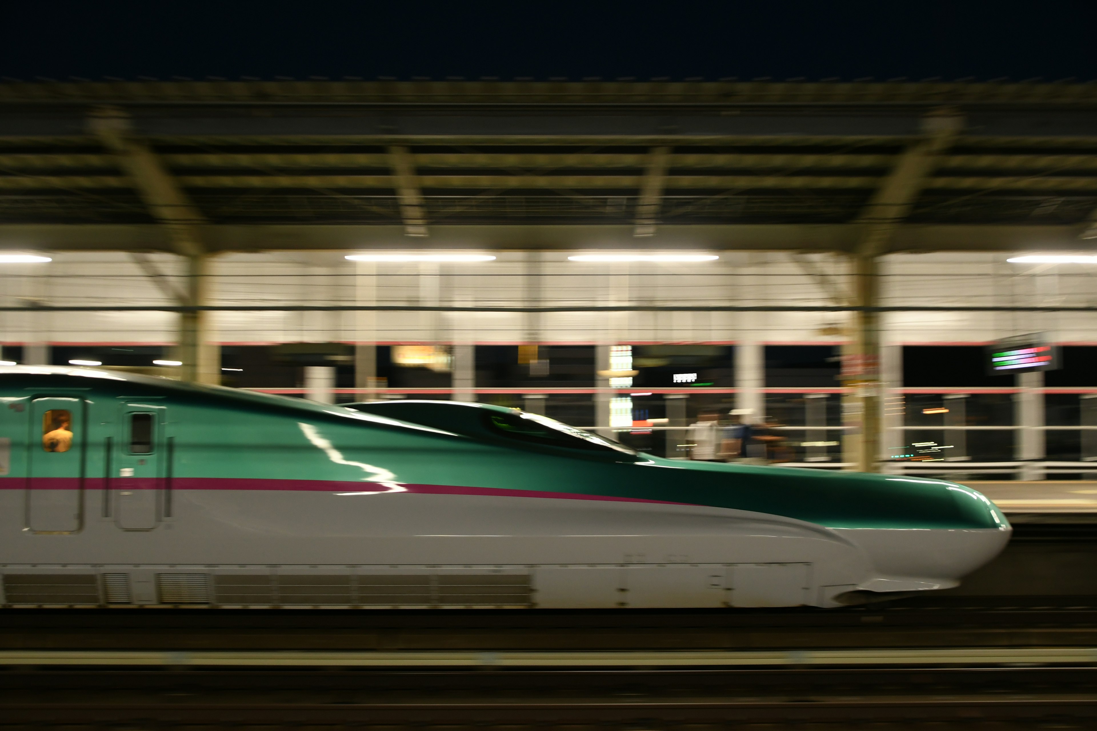 Shinkansen train in motion at night station