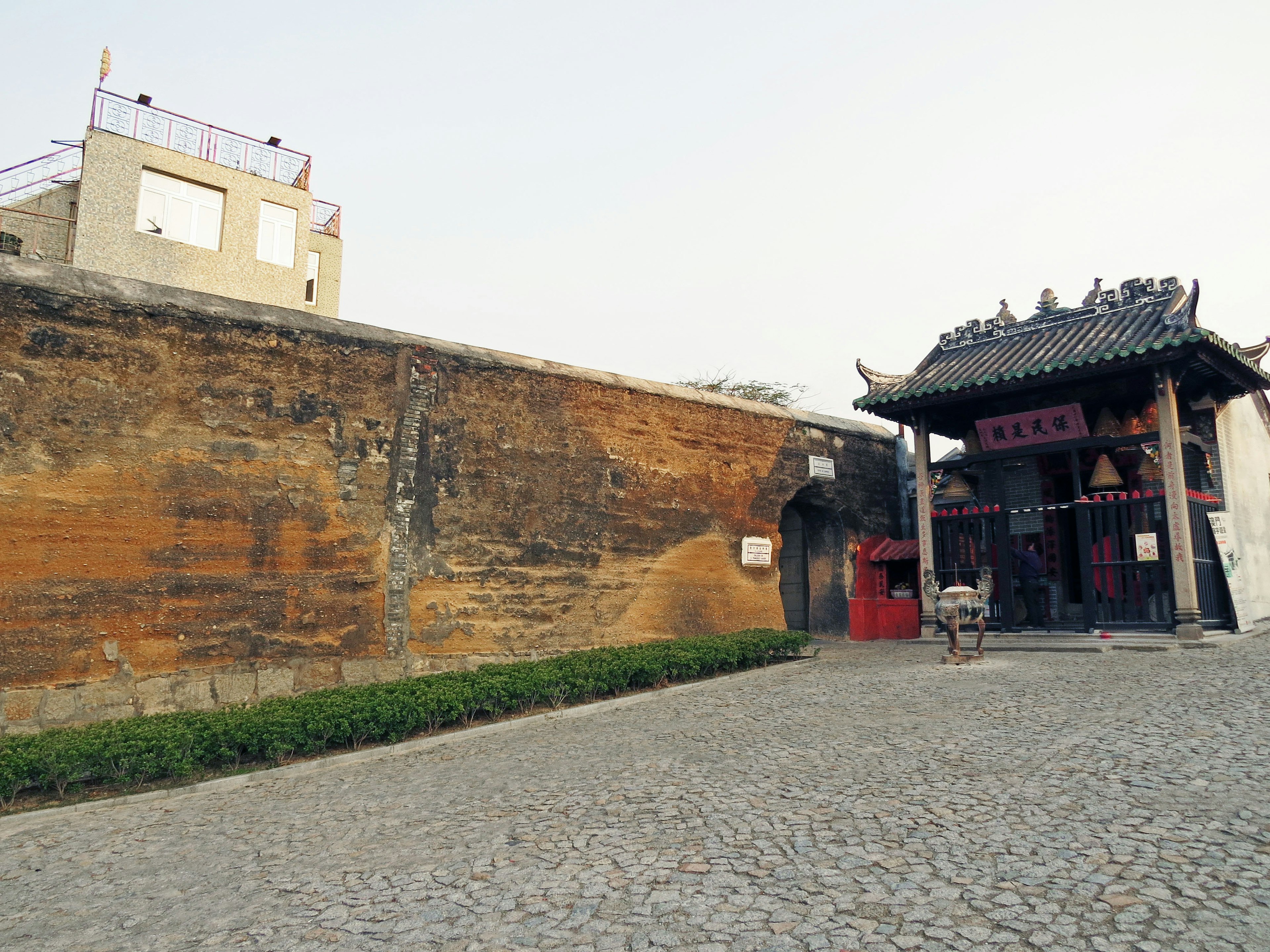 Una vista que presenta una antigua muralla y un edificio tradicional