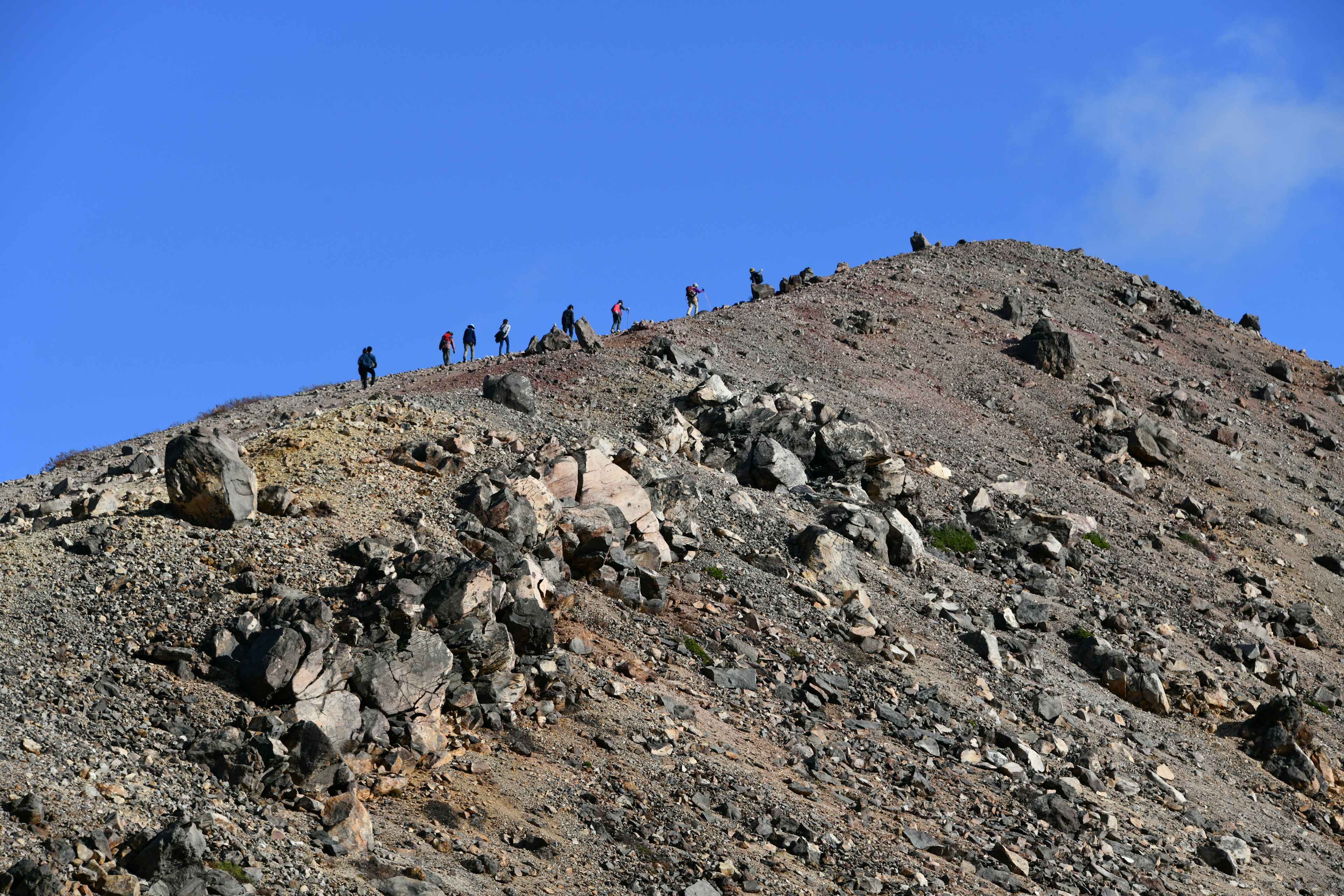 Randonneurs sur la crête d'une montagne sous un ciel bleu