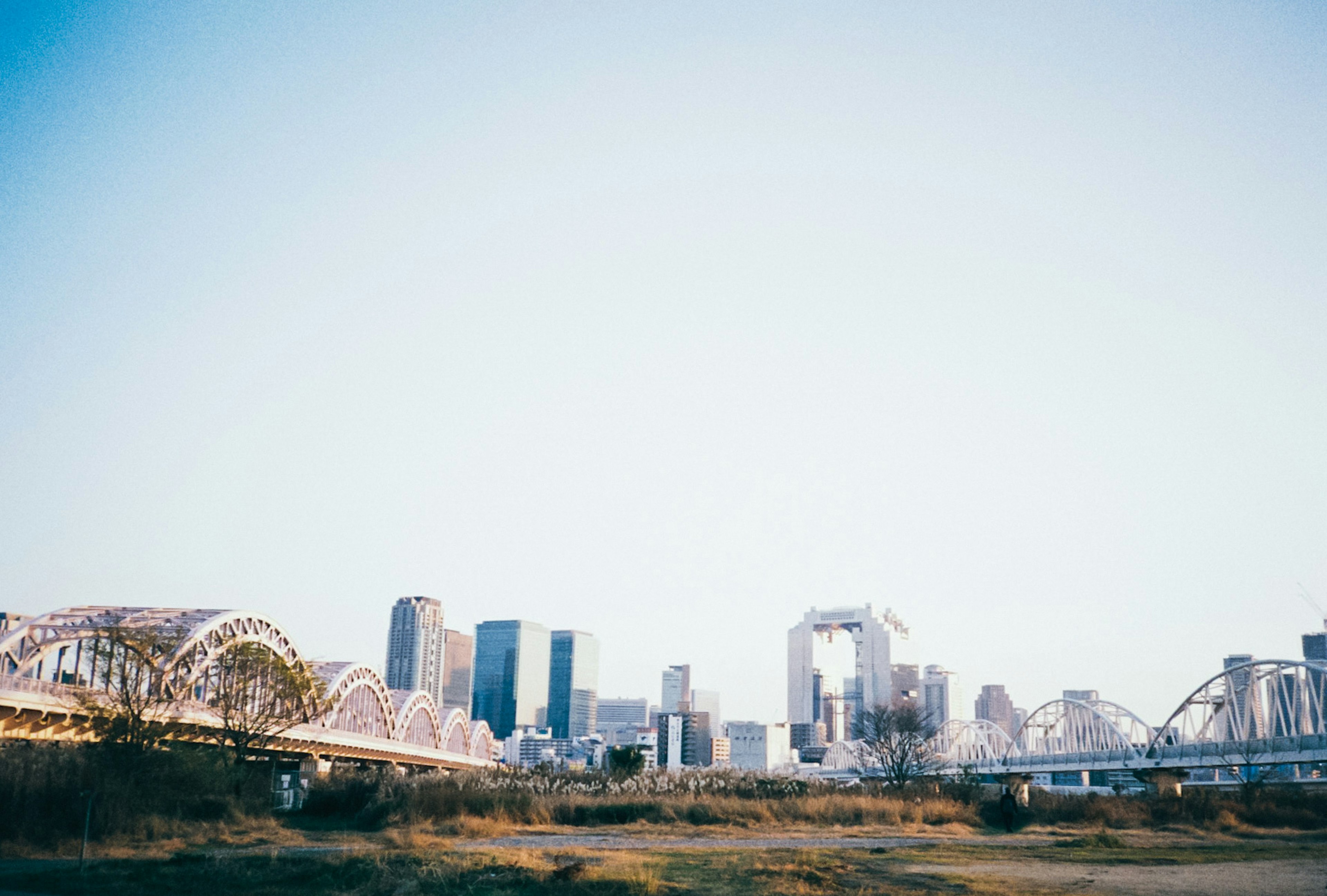 Silhouette de la ciudad con puentes bajo un cielo azul claro