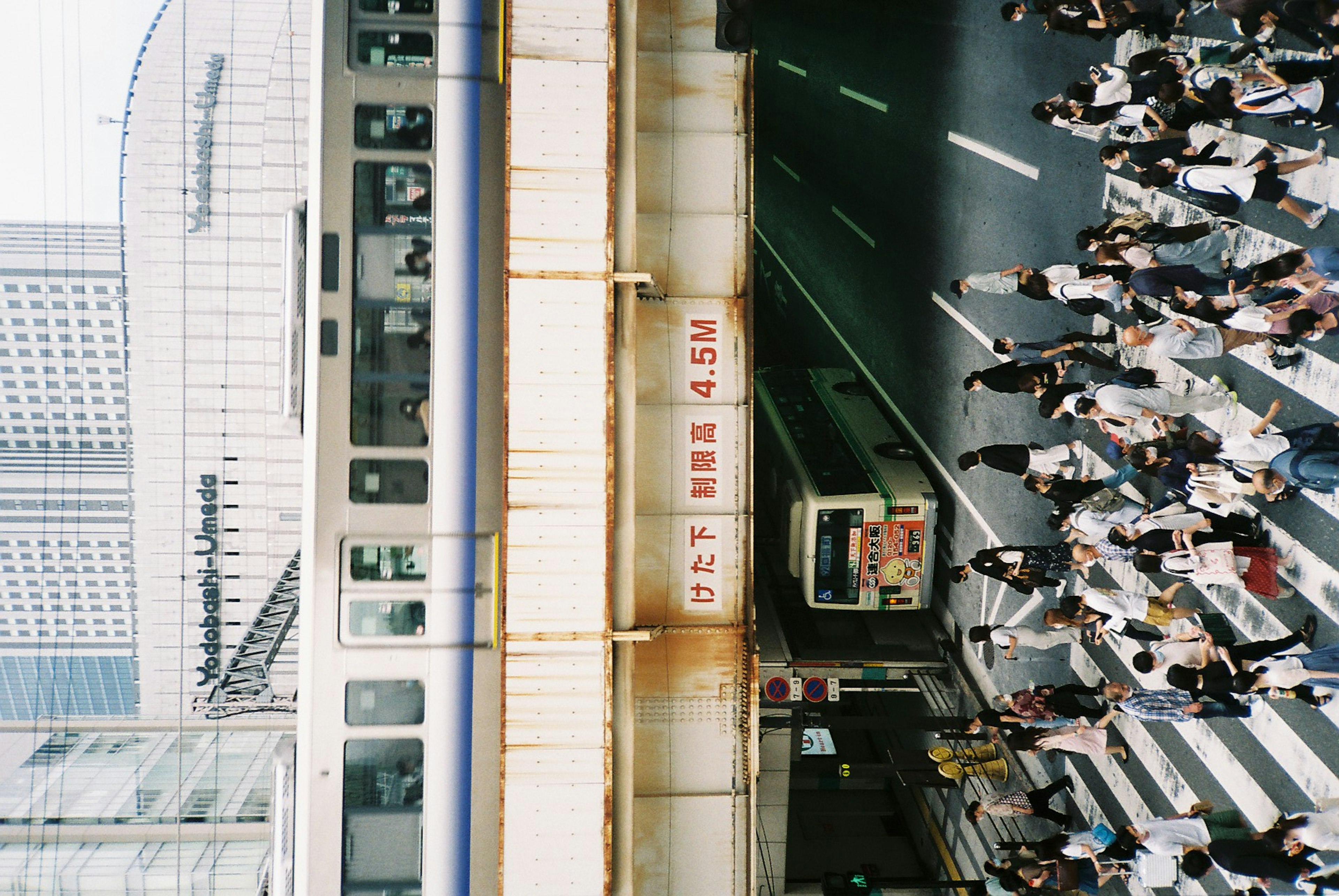 人々が交差点を渡る都市の風景と電車