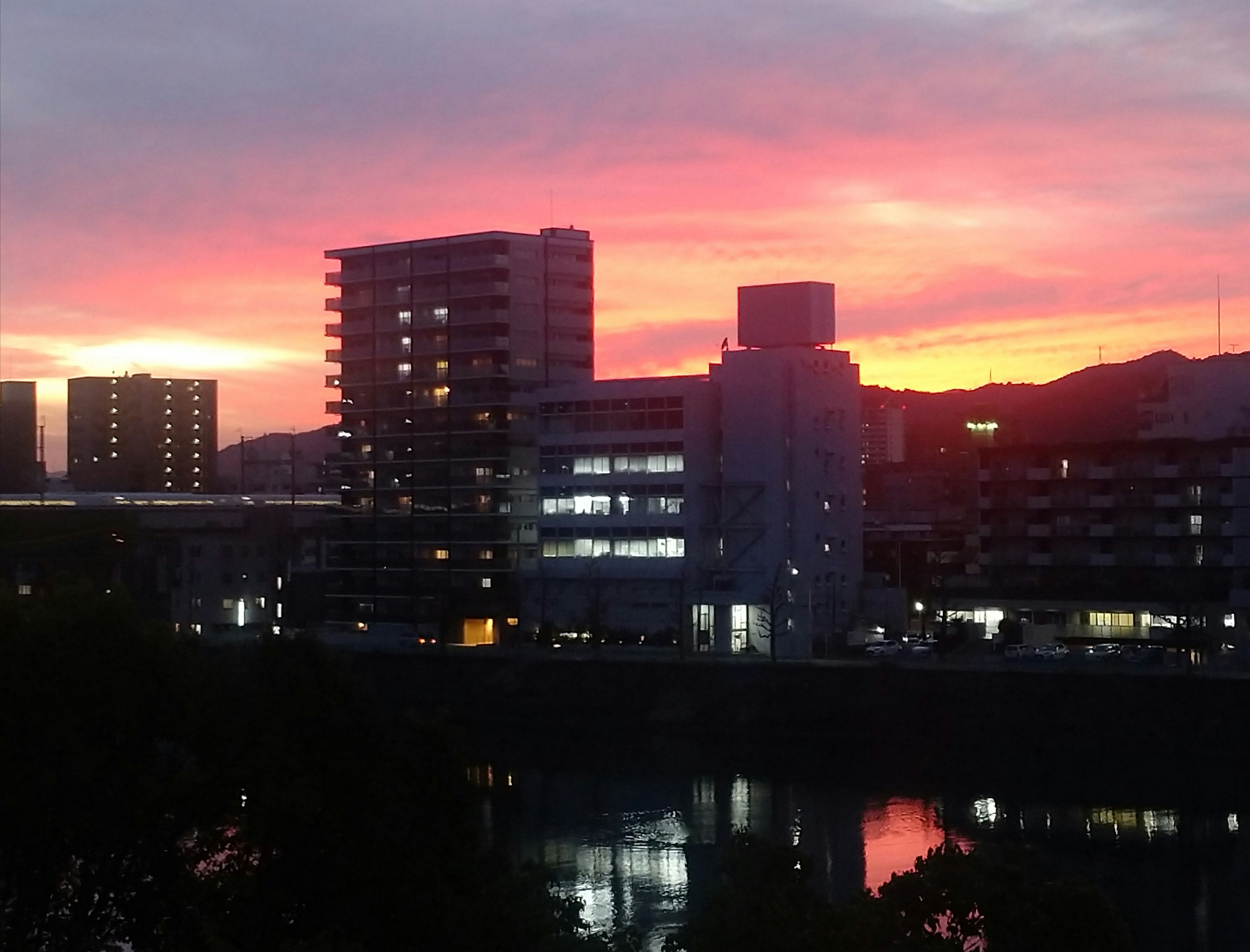 Cityscape illuminated by sunset buildings and reflections on water