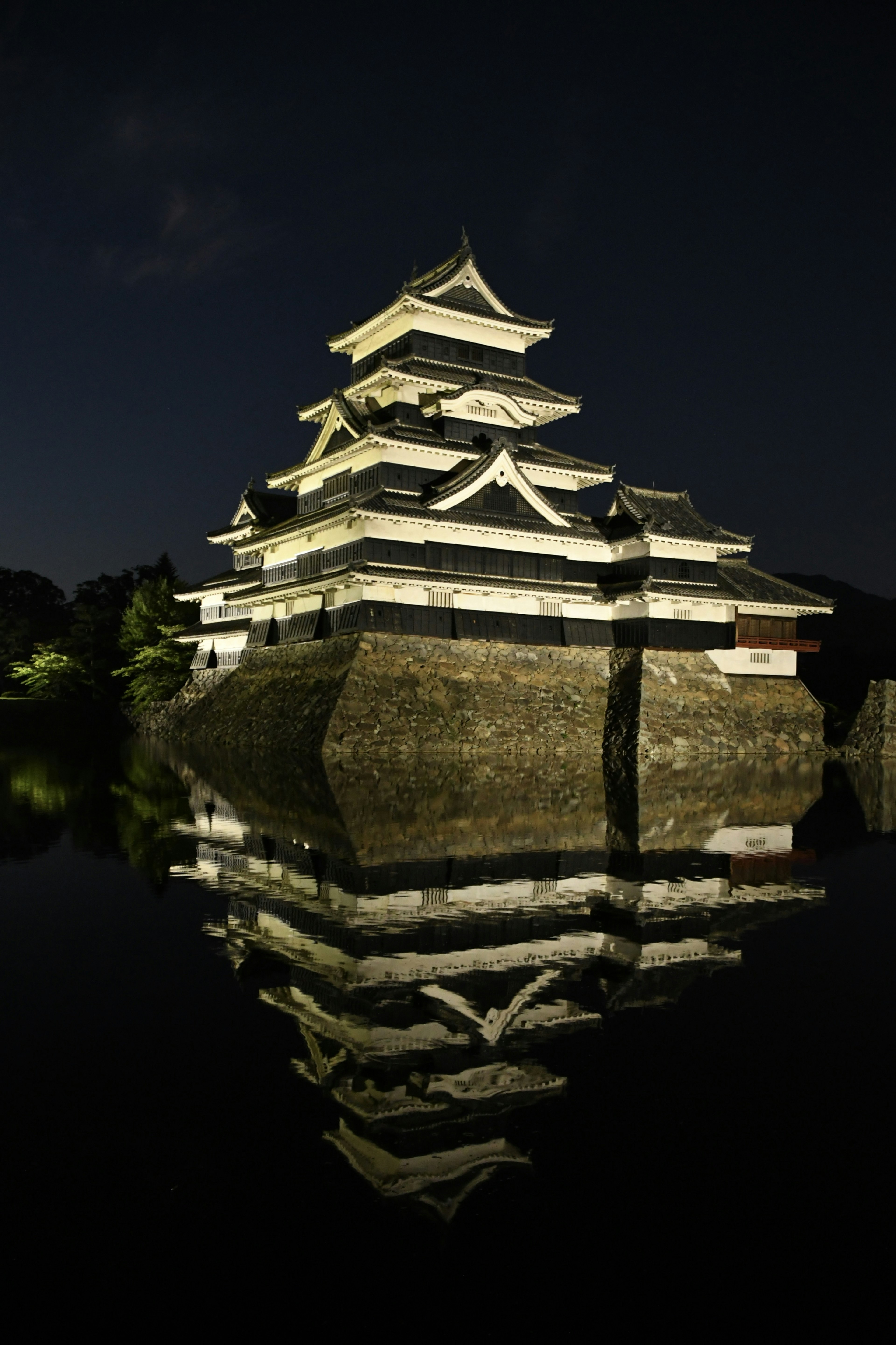 Castello di Matsumoto di notte con riflesso sull'acqua