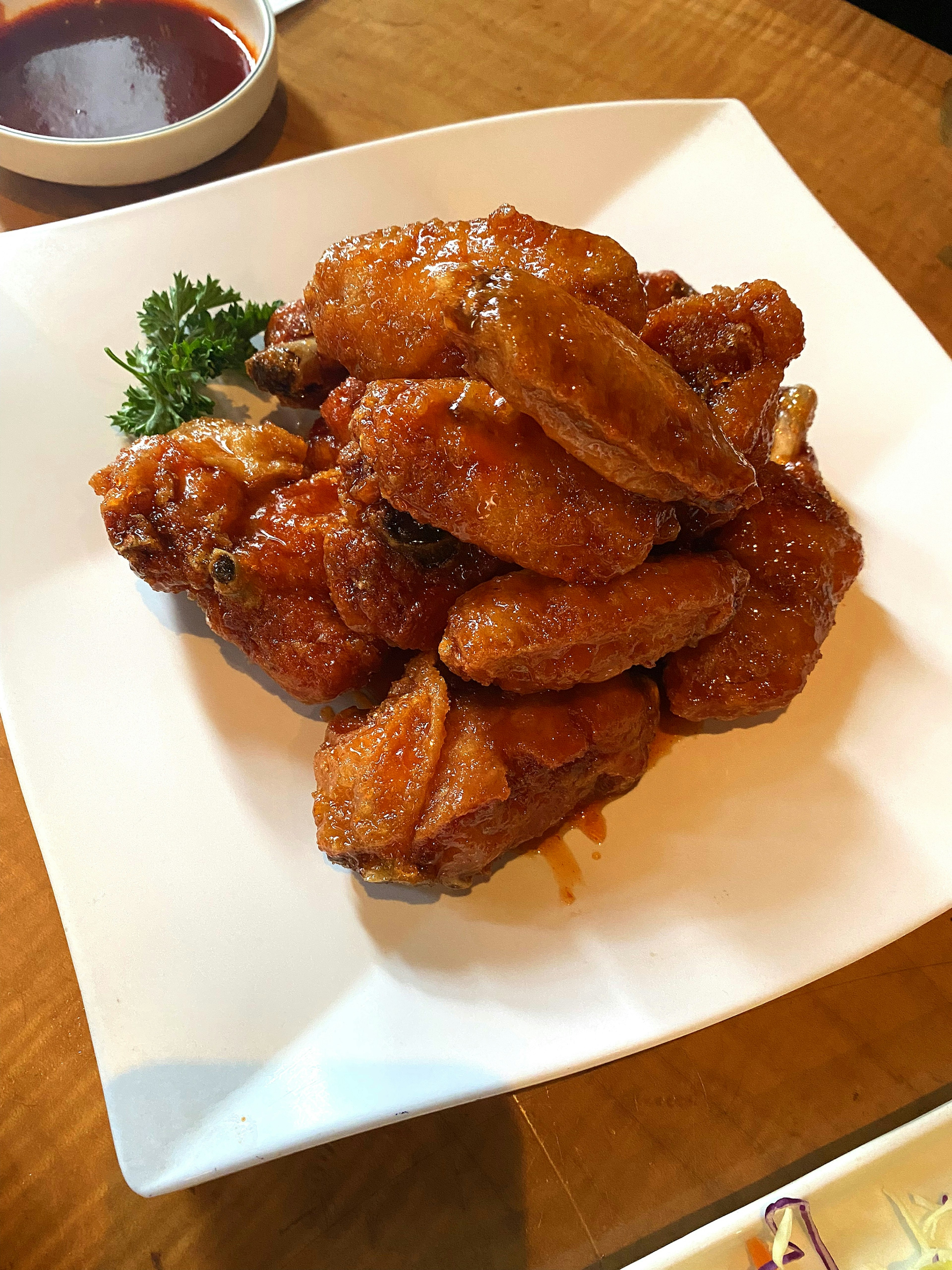 A pile of sweet and spicy chicken wings on a white plate