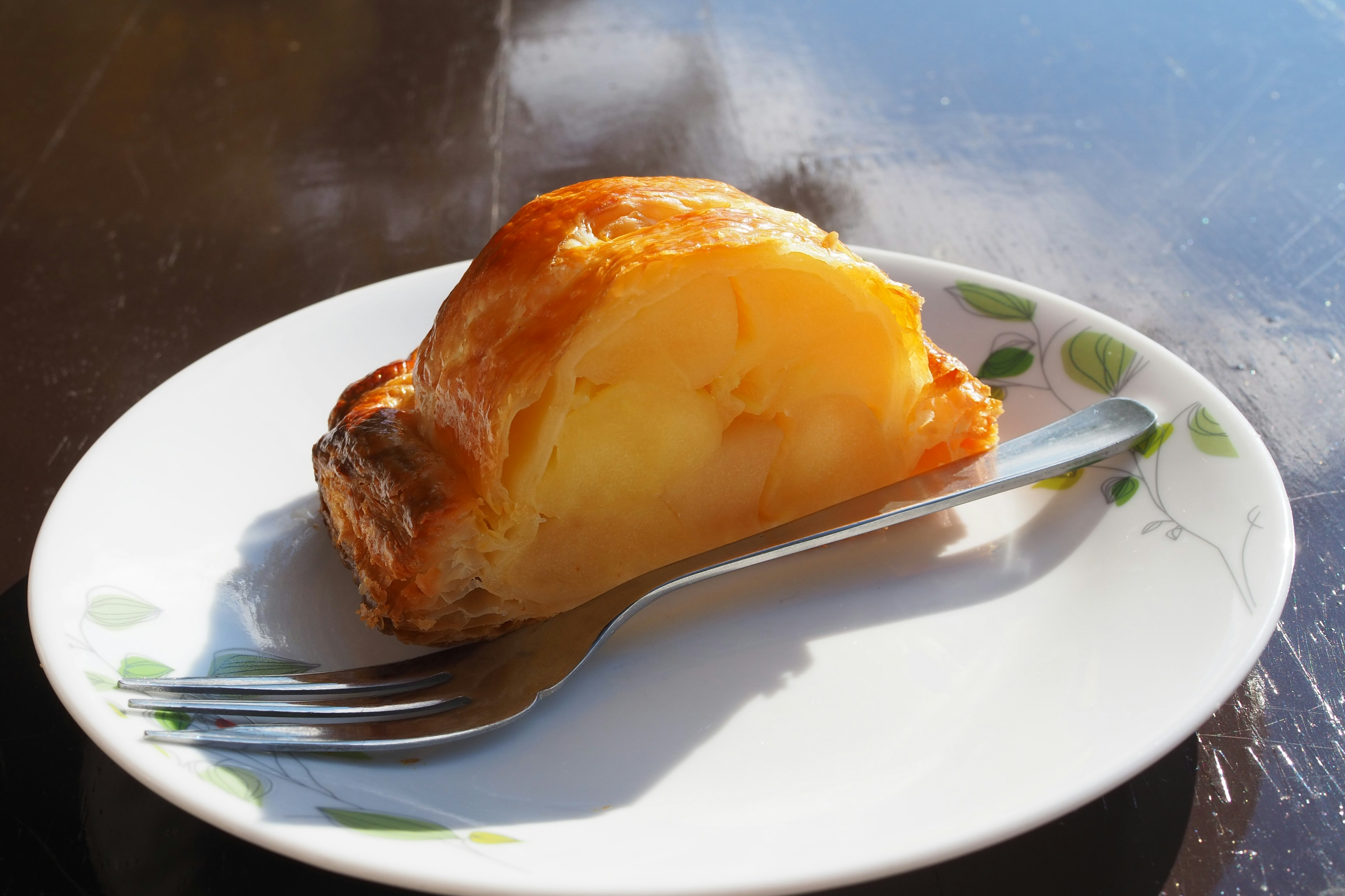 Slice of baked pastry on a plate with a fork