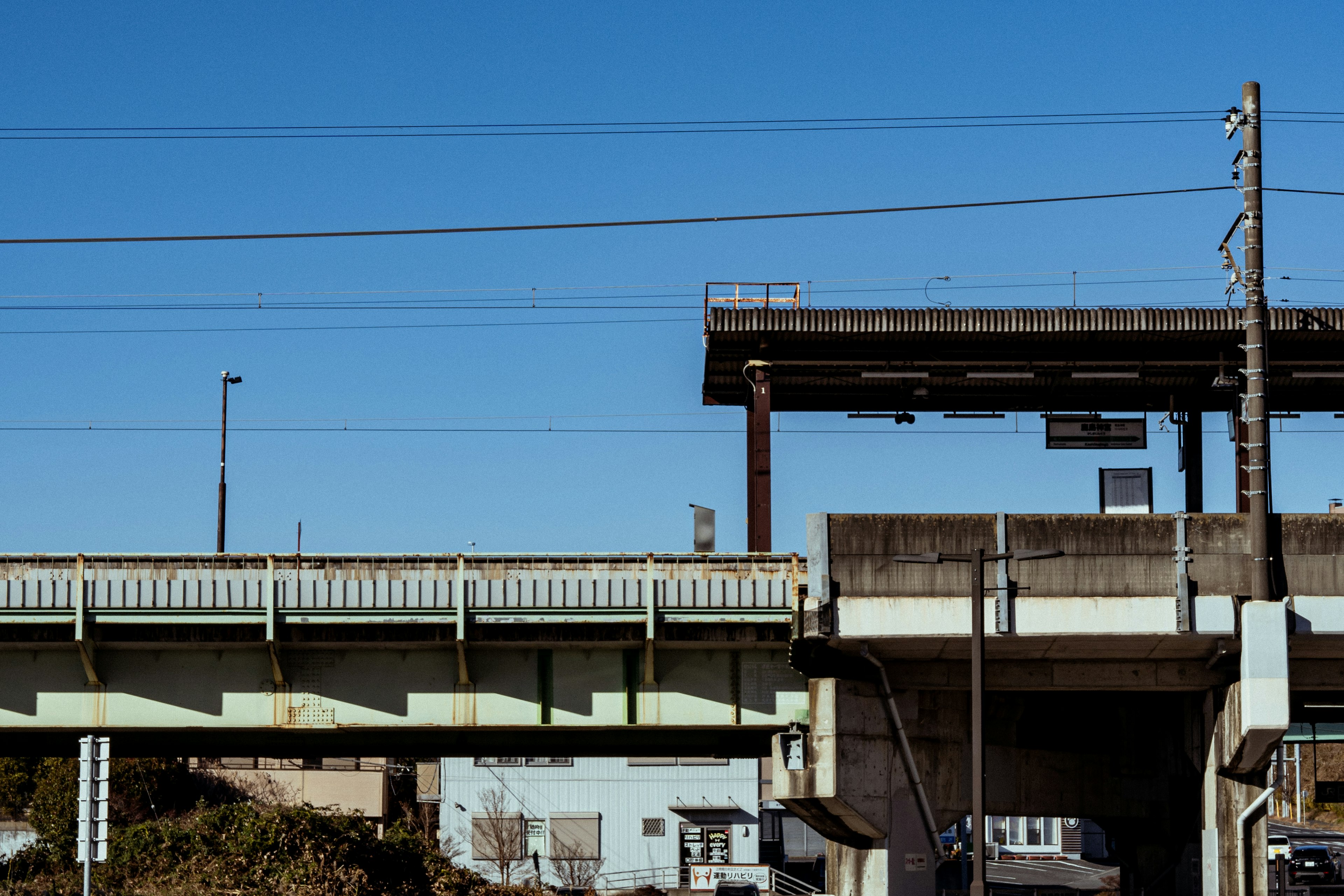 Vue d'une autoroute surélevée avec ciel bleu présentant des panneaux de signalisation et des poteaux utilitaires