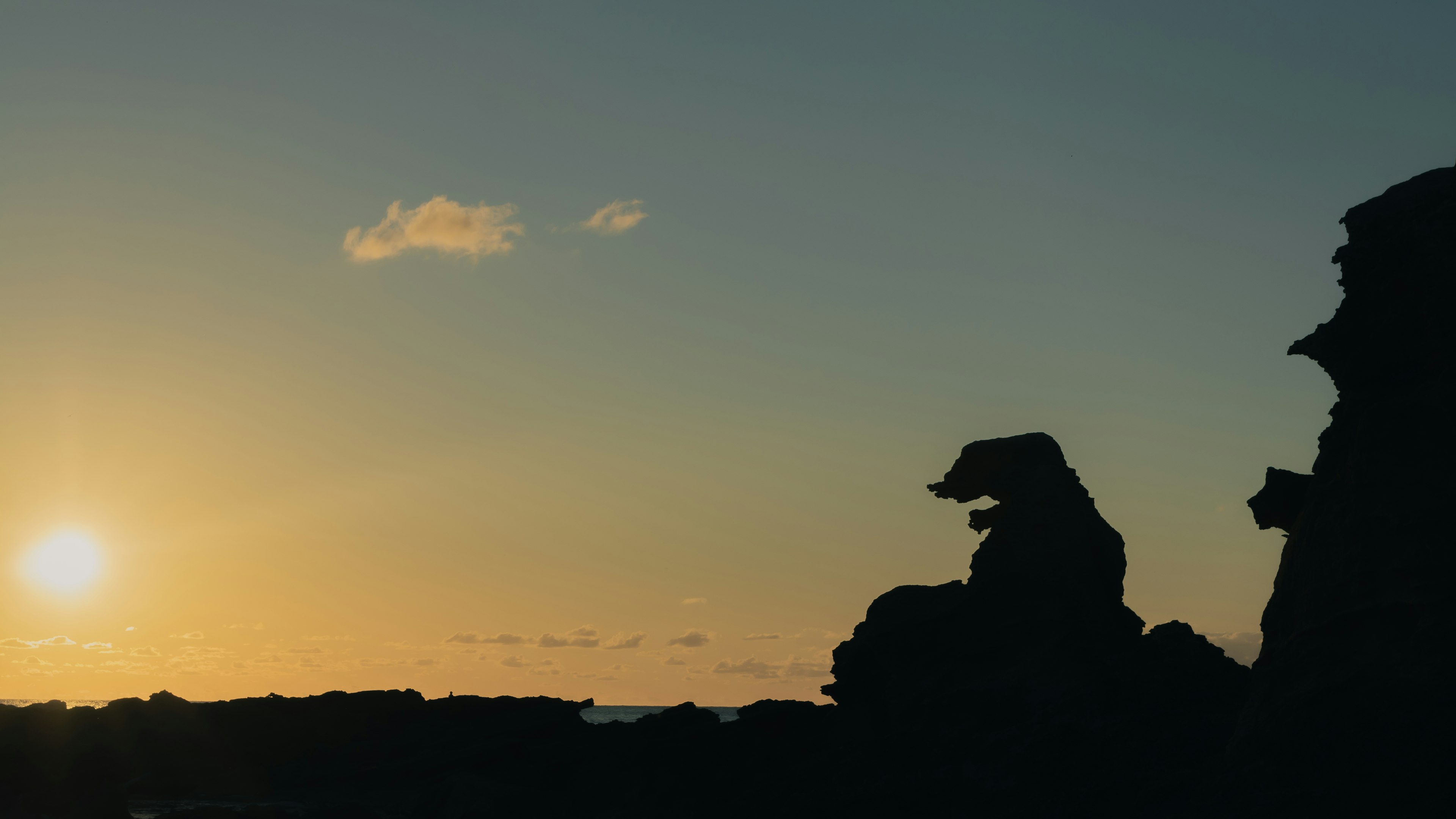 Silhouette of rocks against a sunset sky