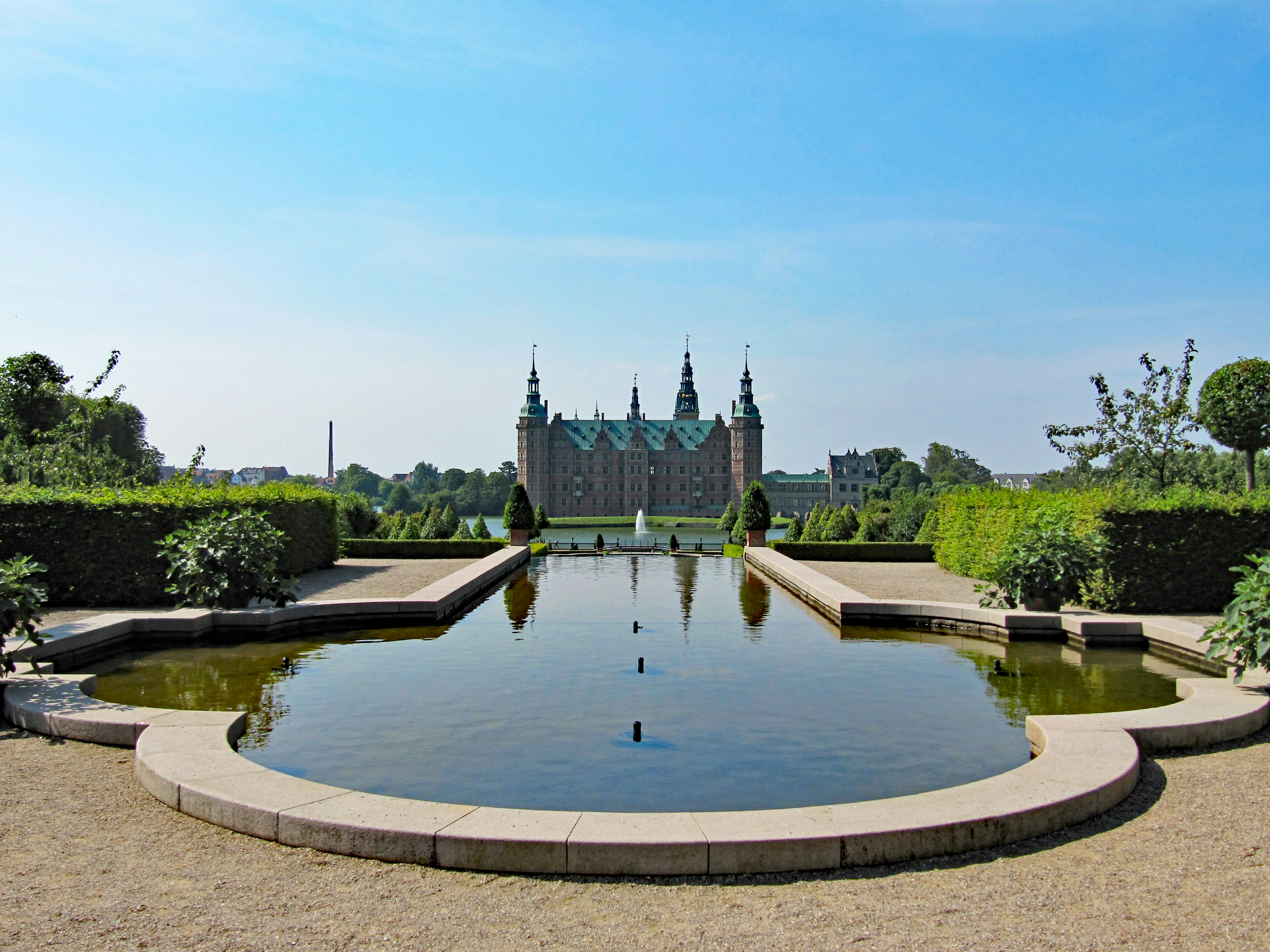 A picturesque garden pond with a grand castle in the background