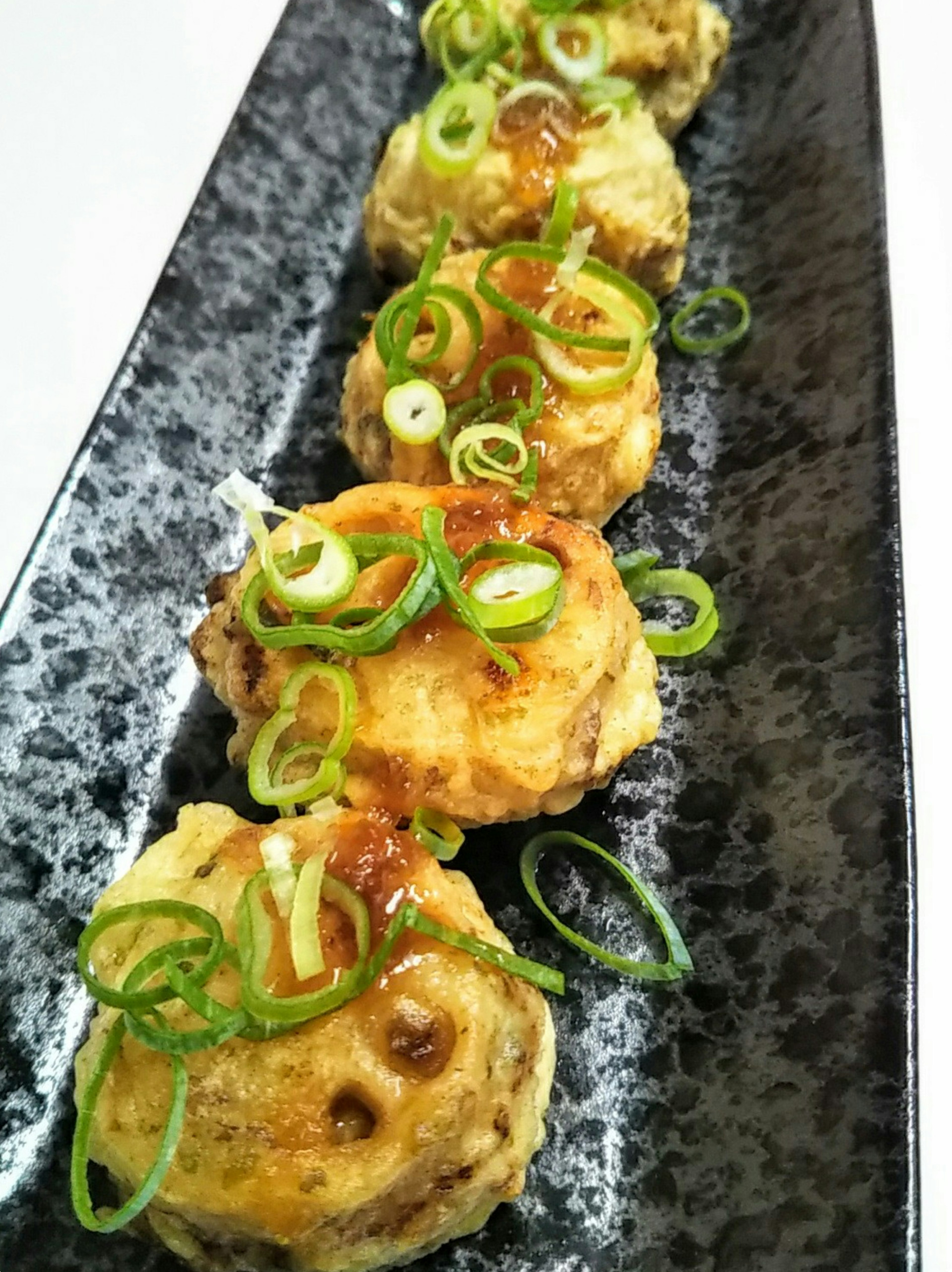 Un hermoso plato de comida frita decorado con cebollitas verdes