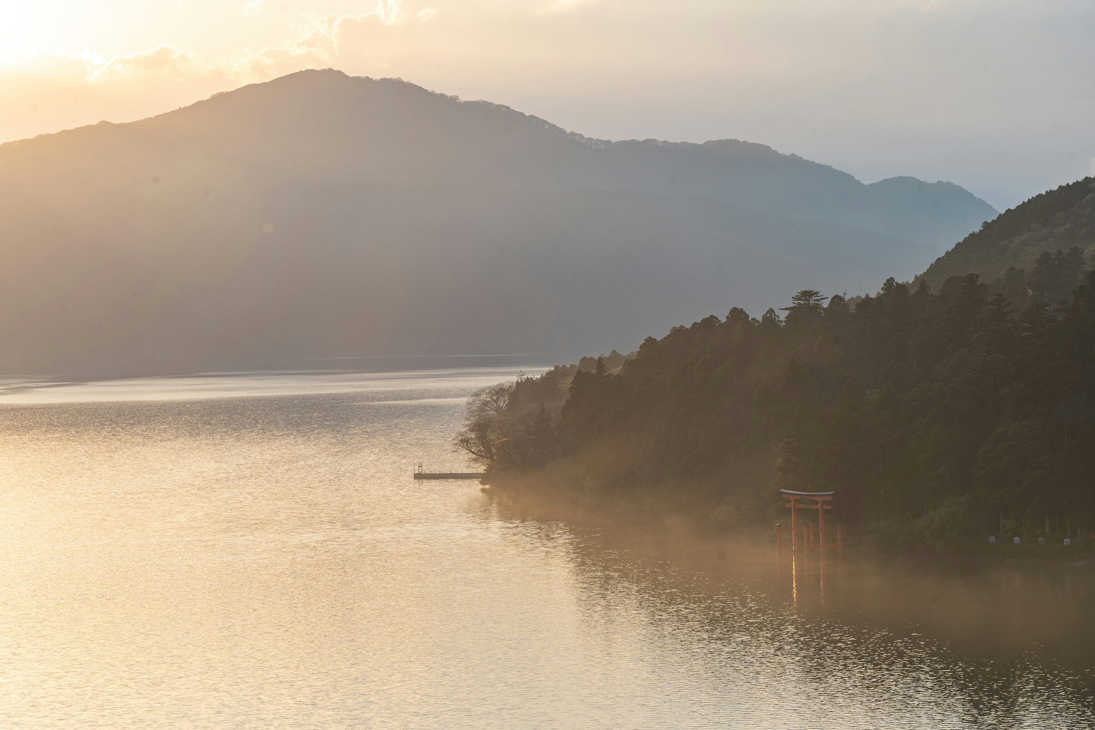 湖と山々の美しい風景　柔らかい夕日が映る穏やかな水面