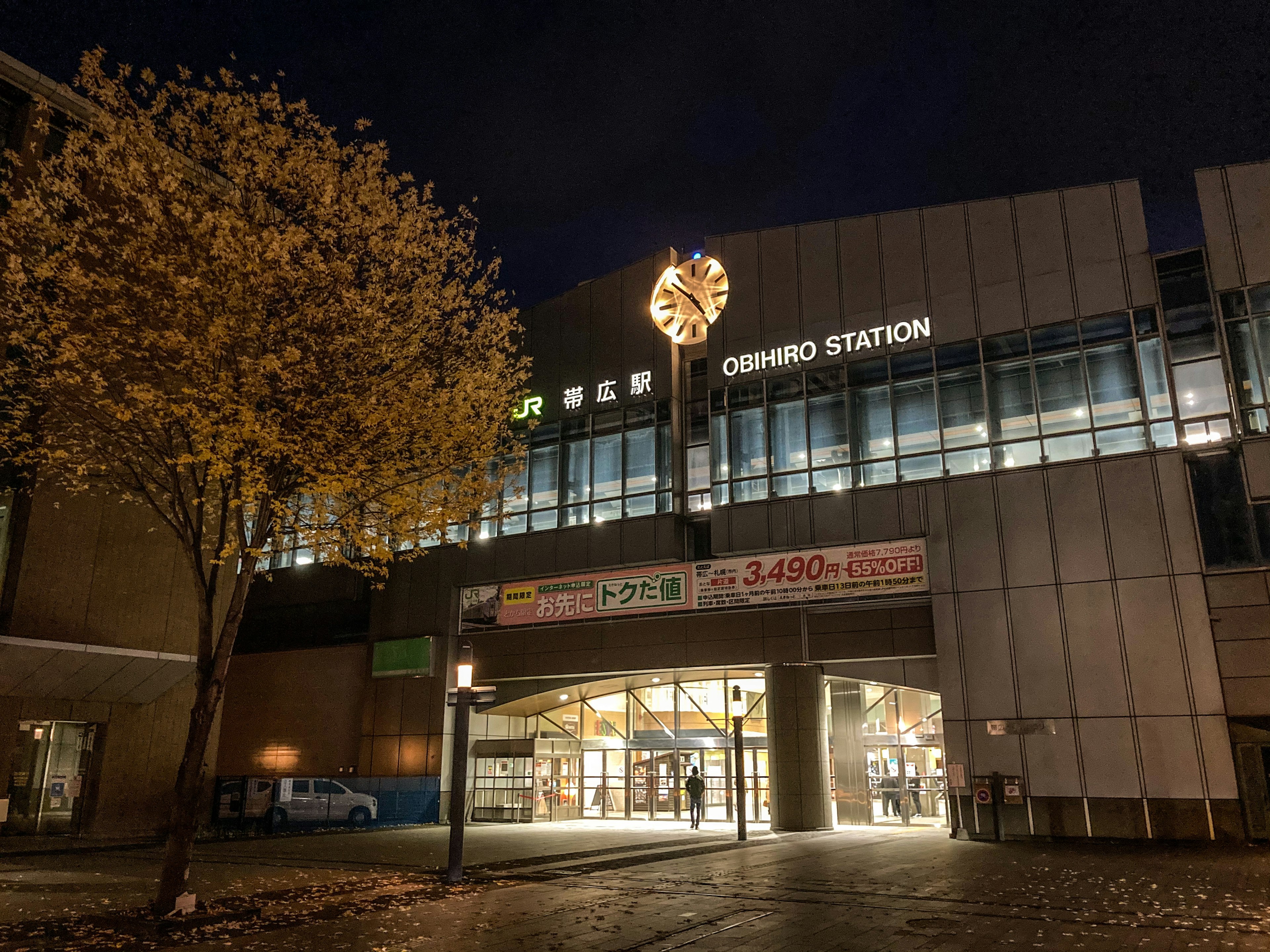 Außenansicht des Omori-Bahnhofs bei Nacht mit beleuchteten Schildern