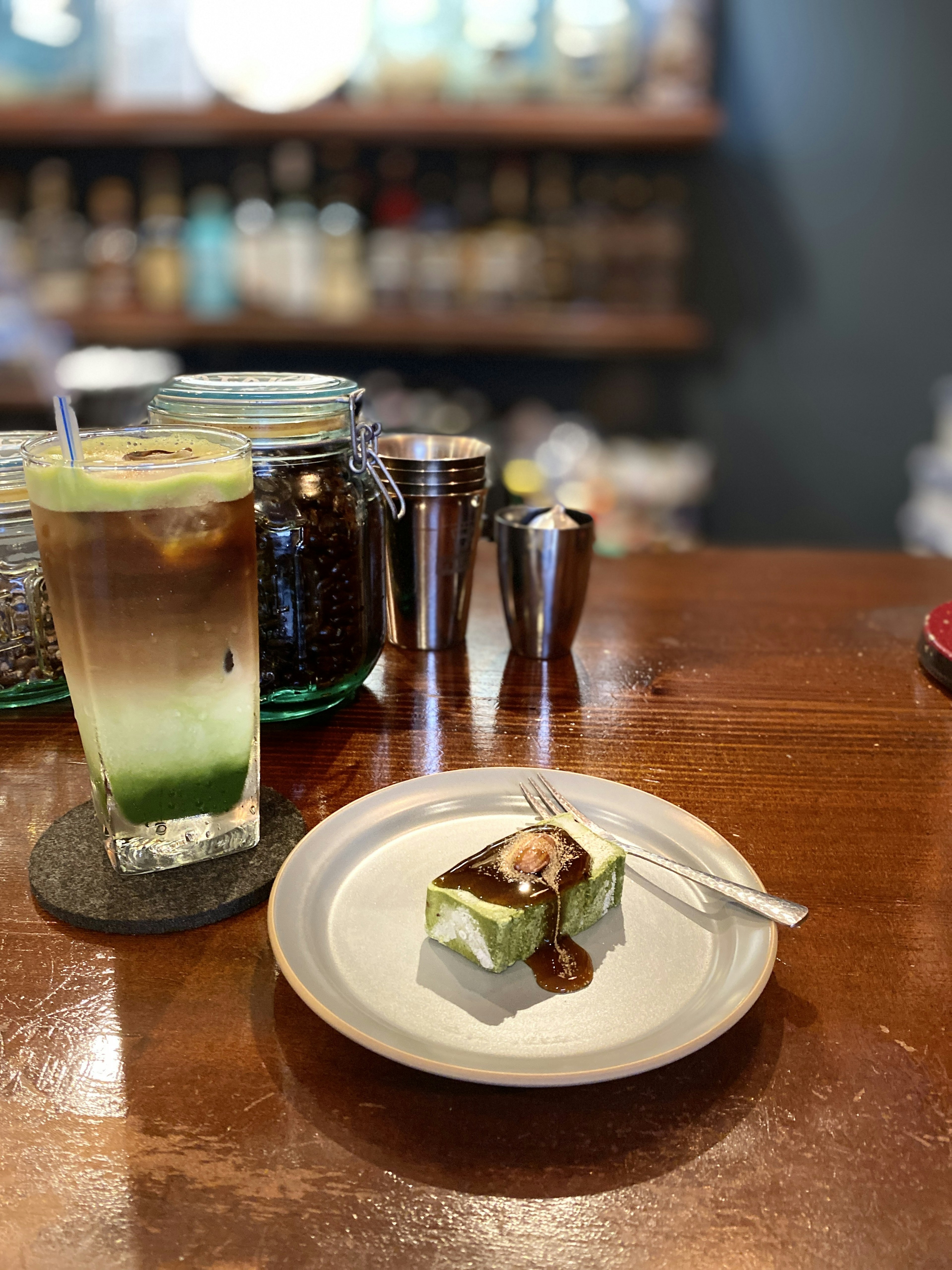 Una foto di una bevanda e un dessert su un bancone Una bevanda verde accanto a un piatto dolce