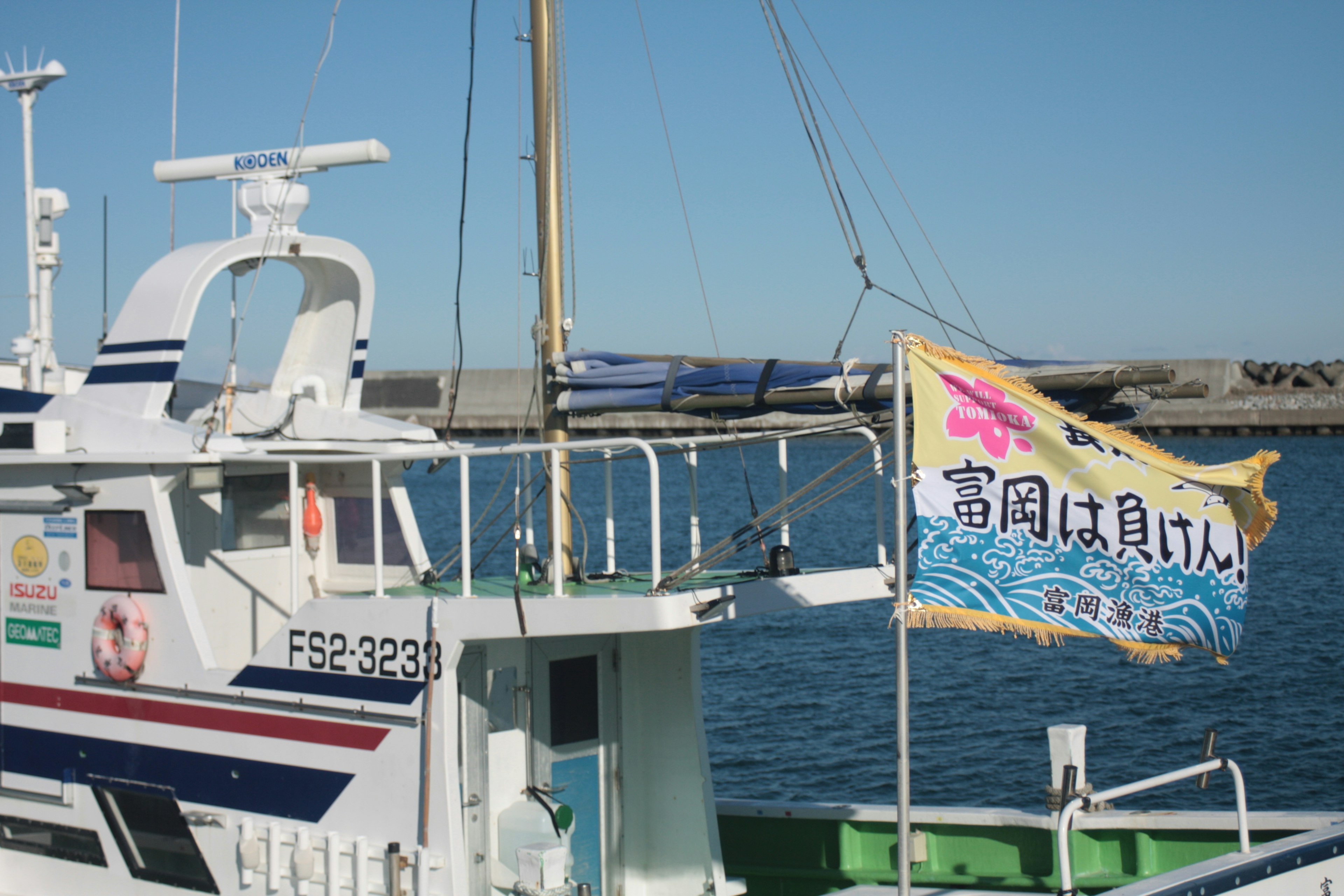 Bandera colorida exhibida en un barco de pesca atracado en el puerto