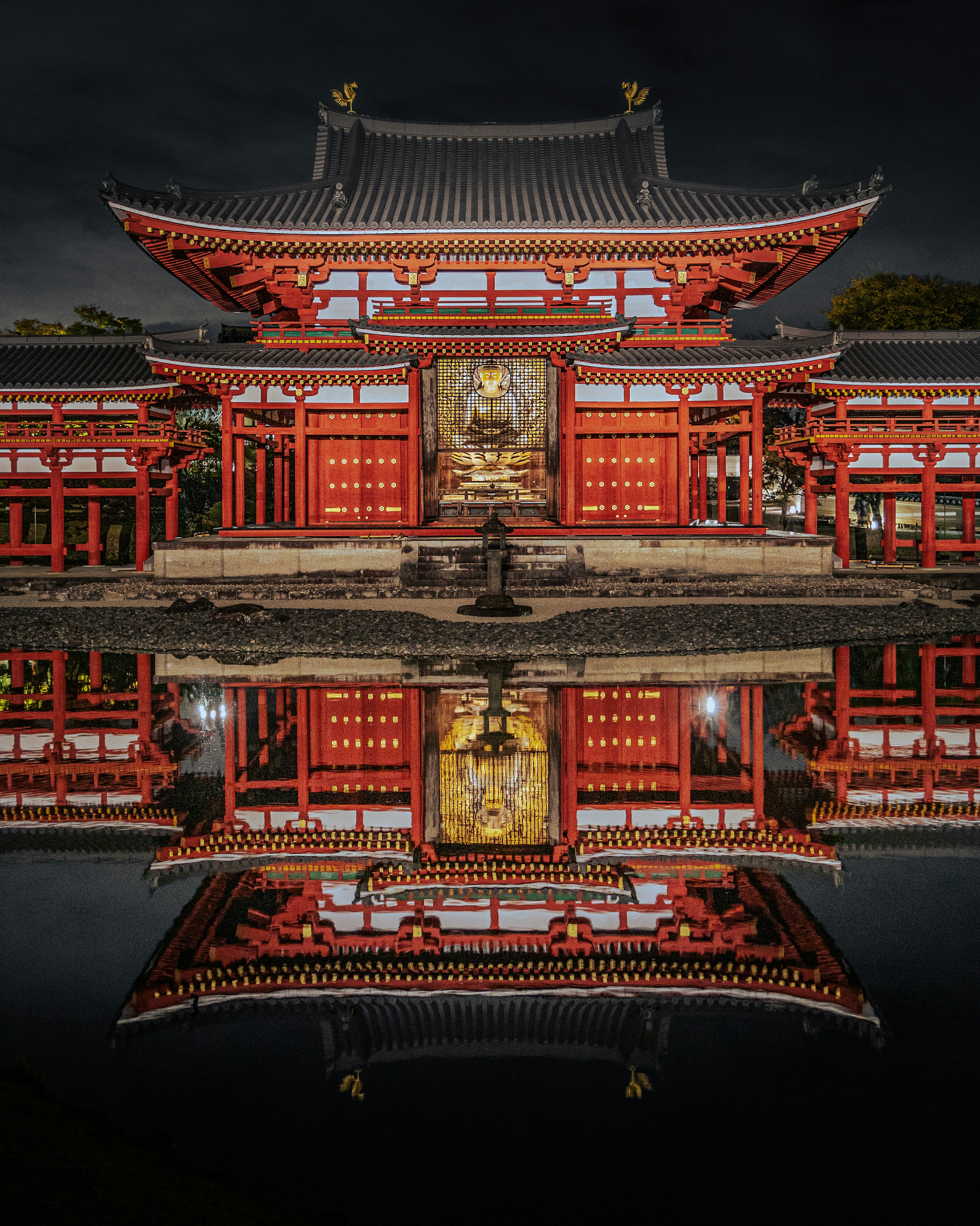 Hermoso edificio rojo reflejándose en el agua tranquila por la noche