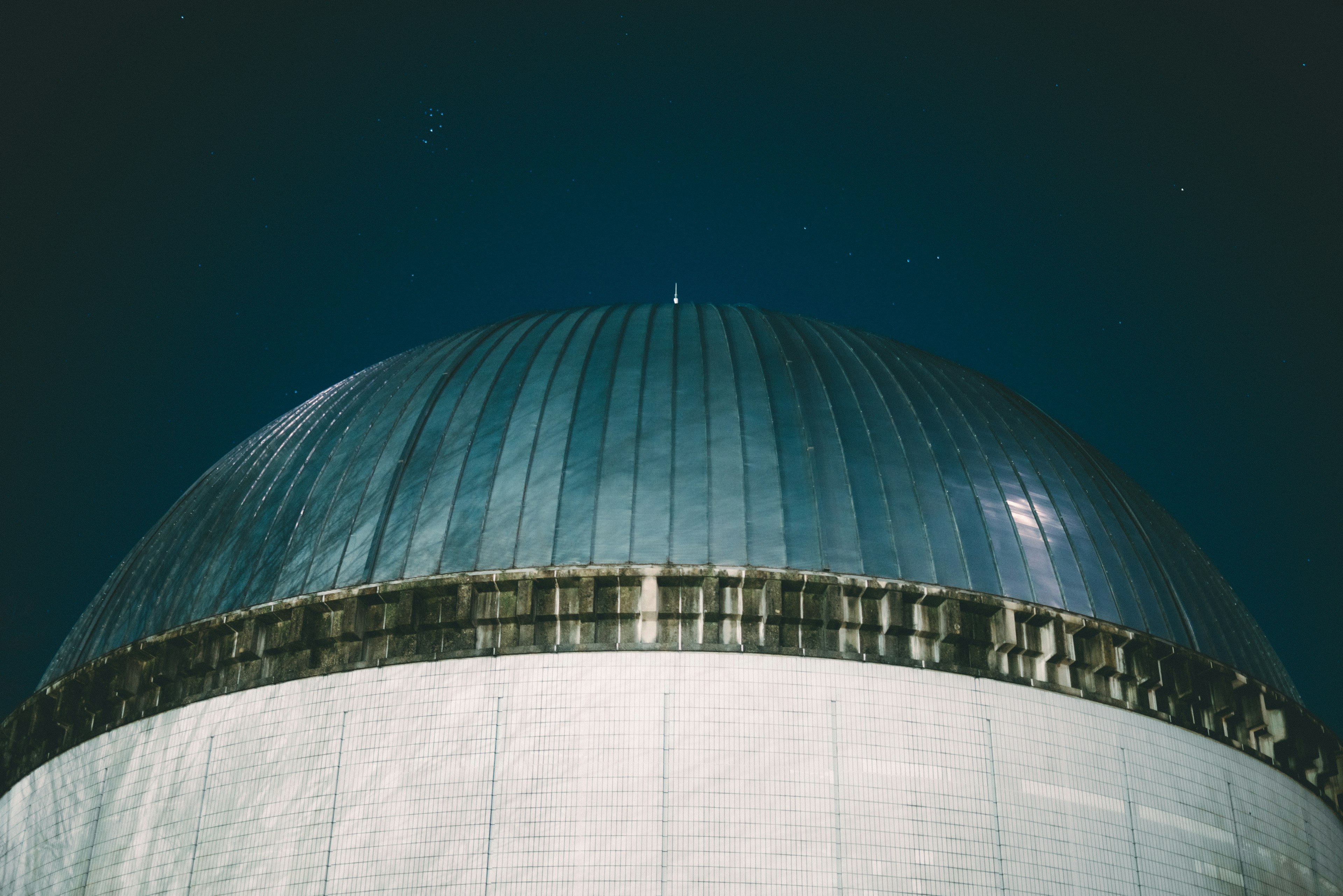 The upper part of a large dome-shaped structure under a blue sky