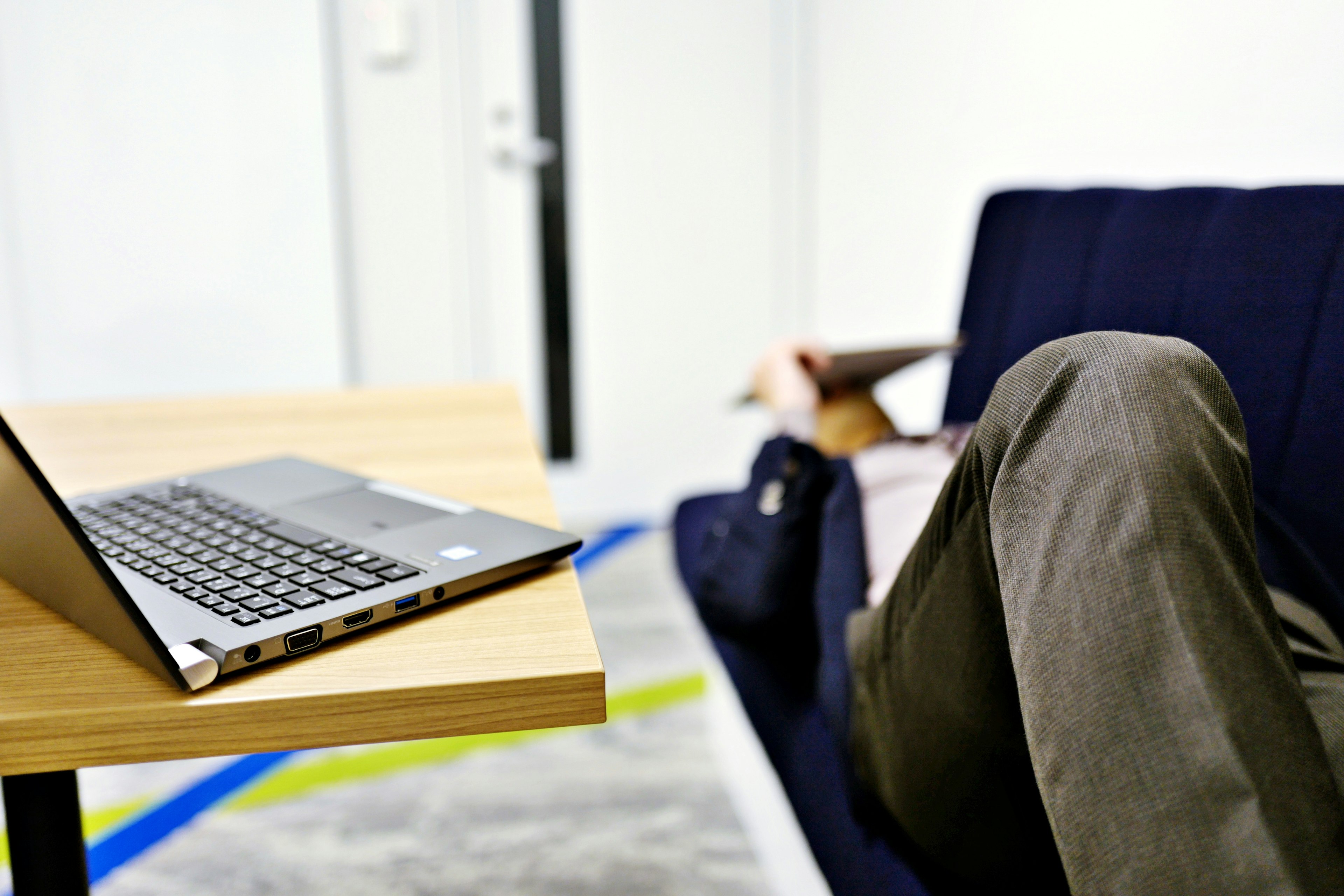 Orang duduk di sofa dengan laptop di meja