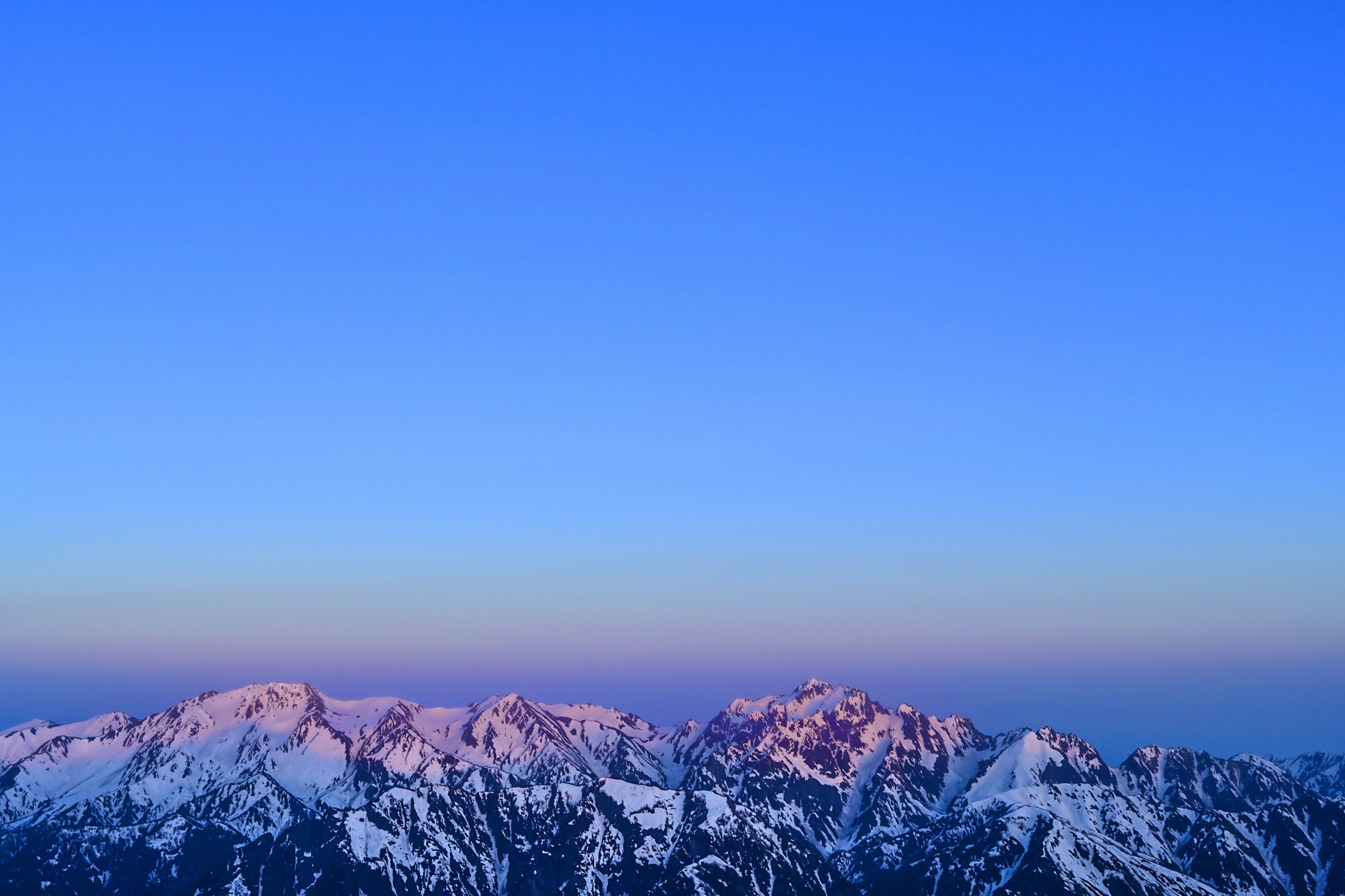 Snow-covered mountains under a clear blue sky