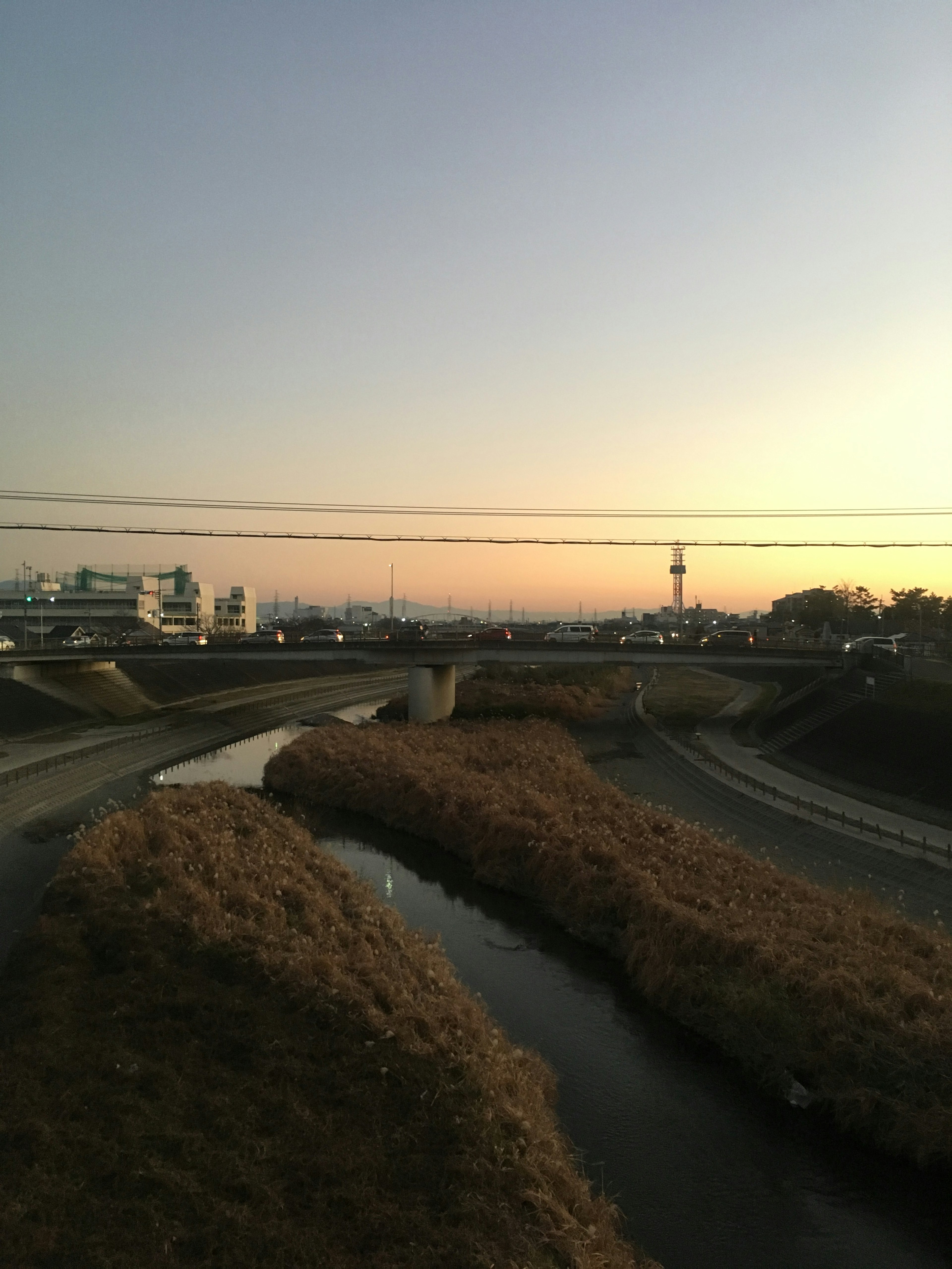 Vista al crepuscolo di un fiume con un ponte e edifici circostanti